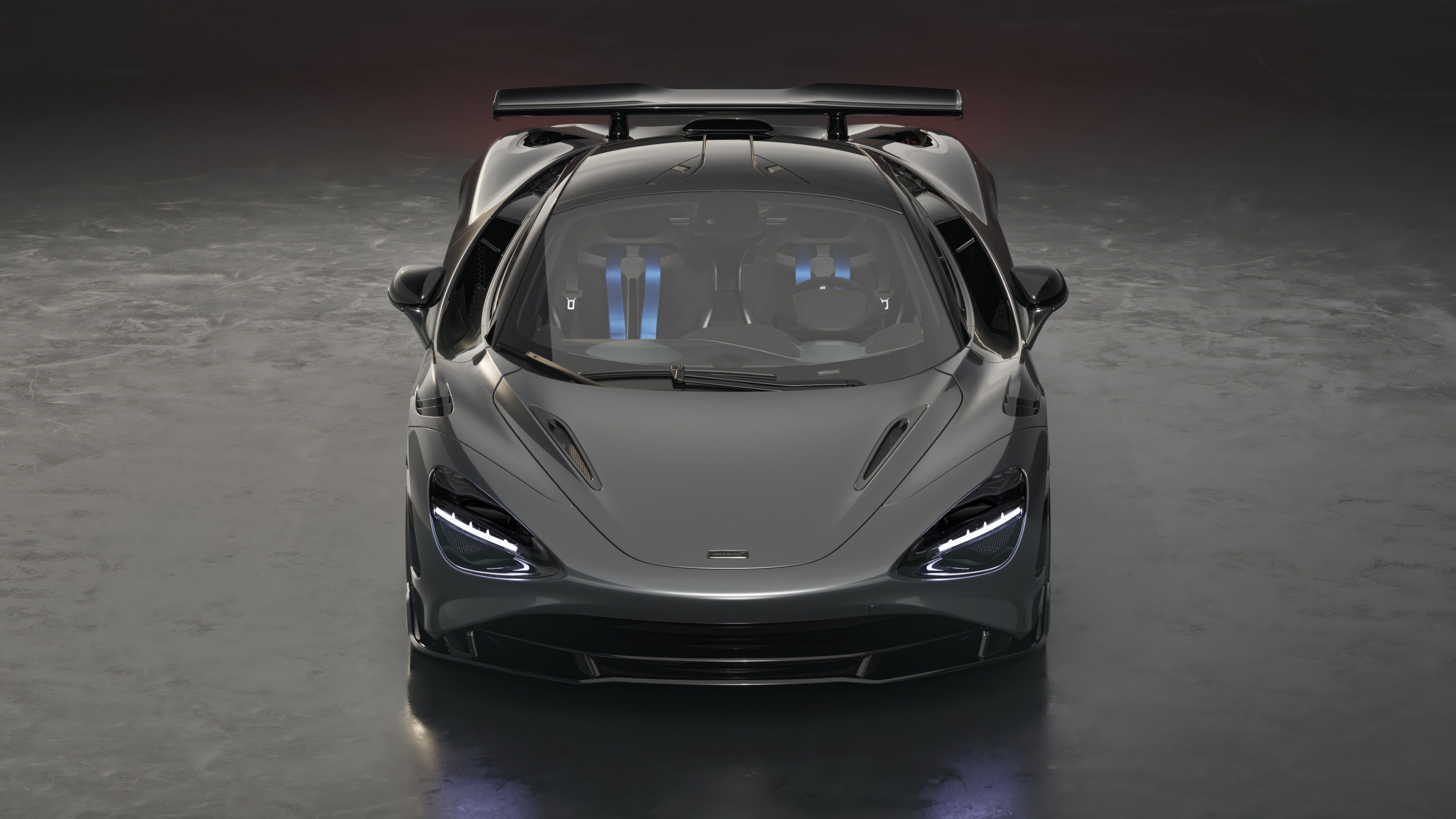 A high-resolution close-up of a McLaren 750S Le Mans supercar, showcasing its aerodynamic body and metallic finish.