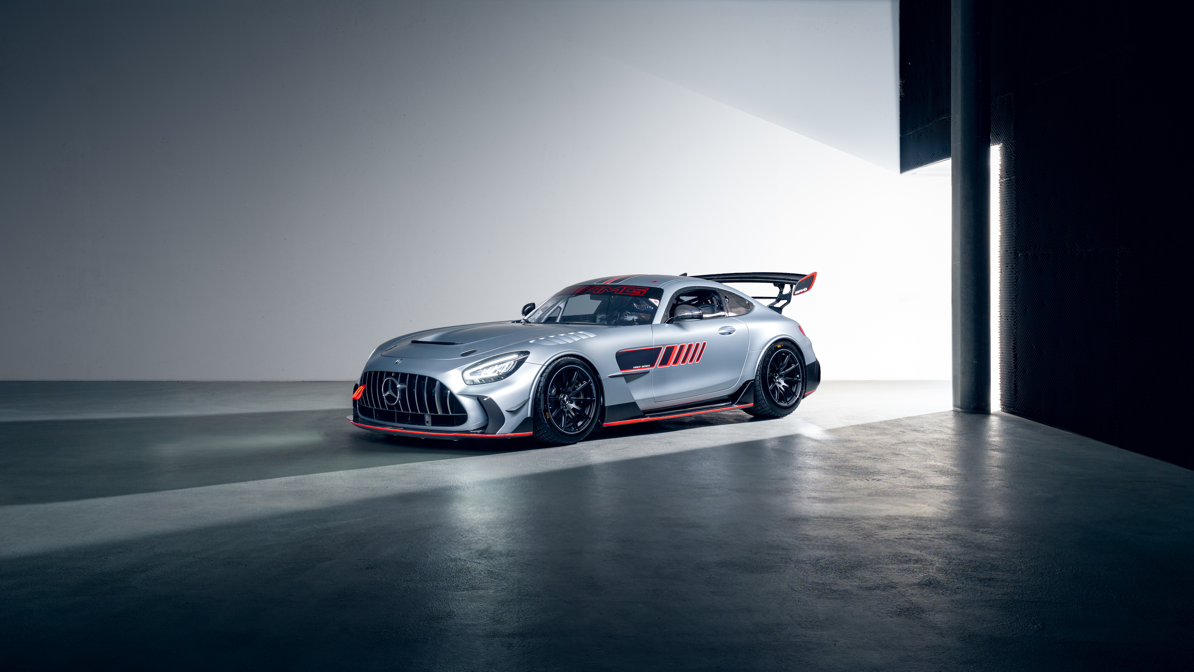 A Mercedes-AMG GT race car navigating a sharp turn on a professional motorsport track.