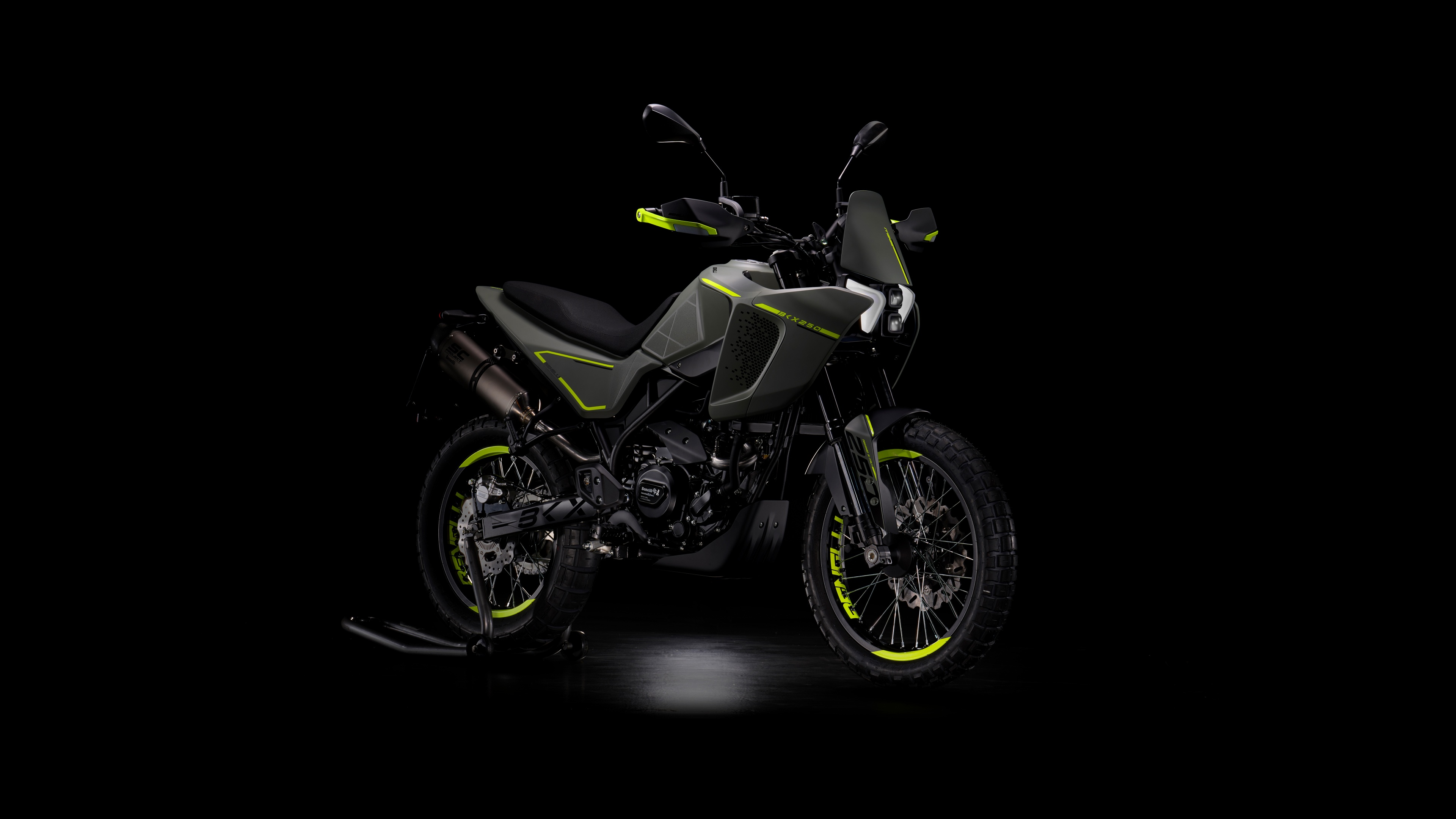 Detailed view of adventure motorcycles with sharp lighting and metallic textures against a pitch-black background.