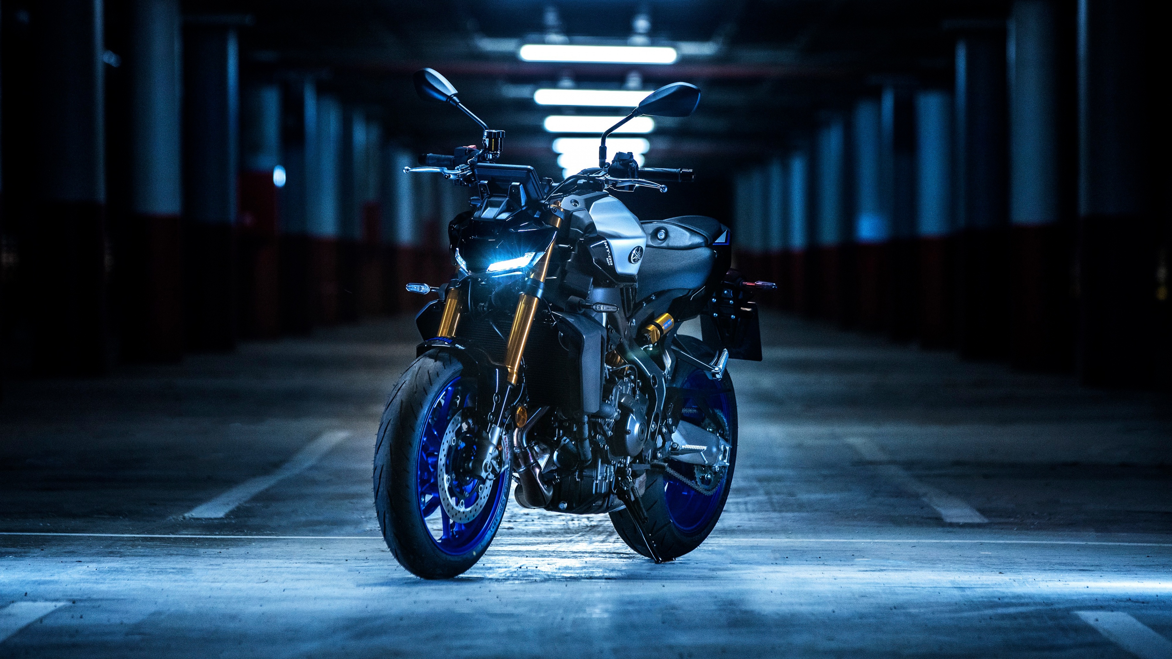 A detailed view of the 2024 Yamaha MT-09 naked motorcycle, emphasizing its aggressive headlight and stripped-back streetfighter design.