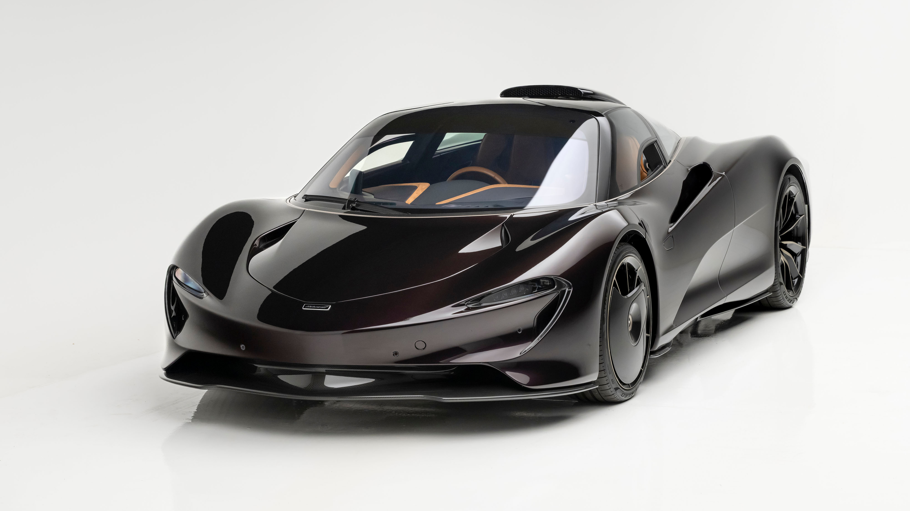 A sleek 2025 McLaren Speedtail hybrid sports car on a plain white background.