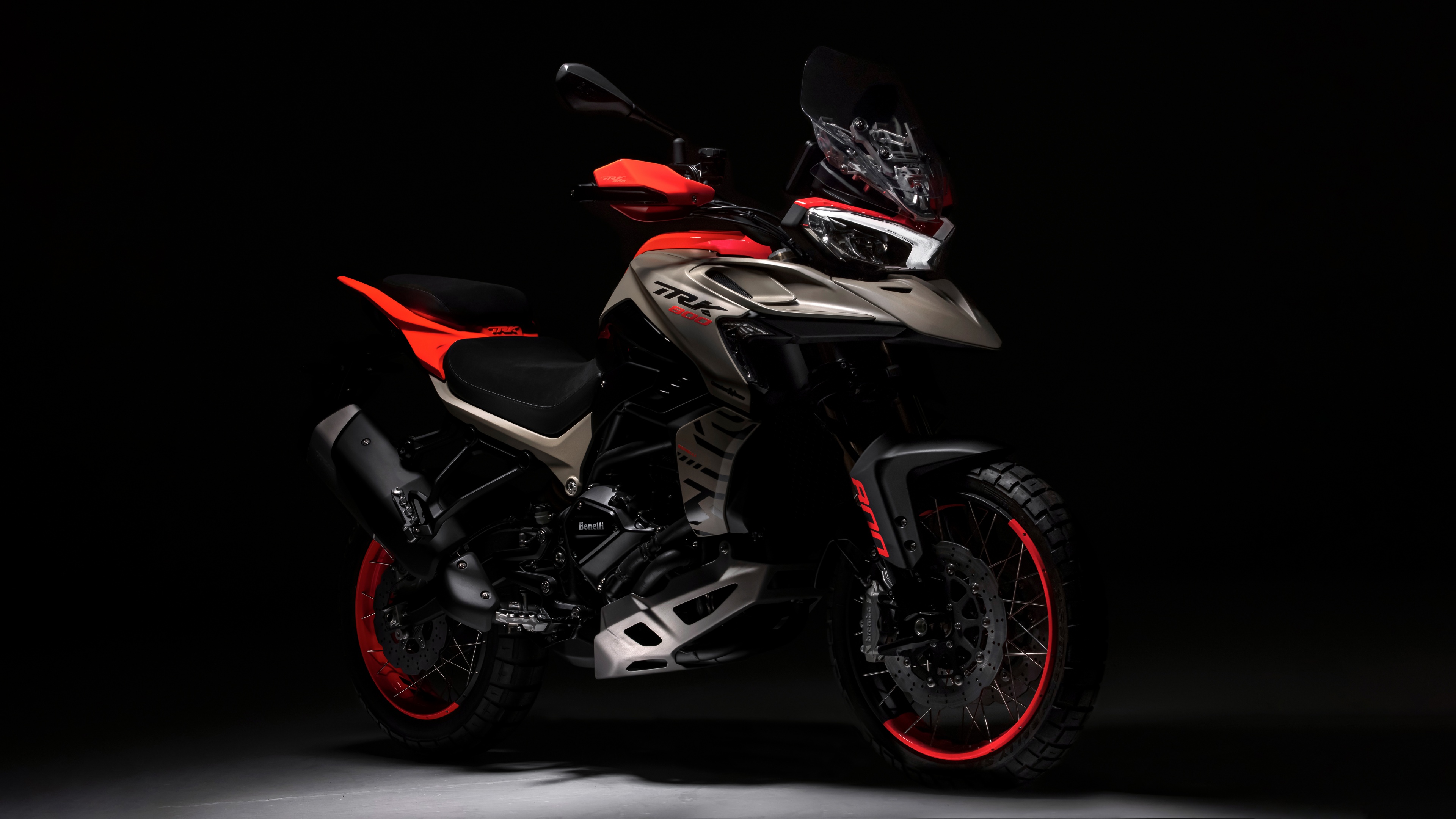 A detailed, cinematic shot of the 2024 Benelli TRK 800 adventure motorcycle against a dark, minimalist background.