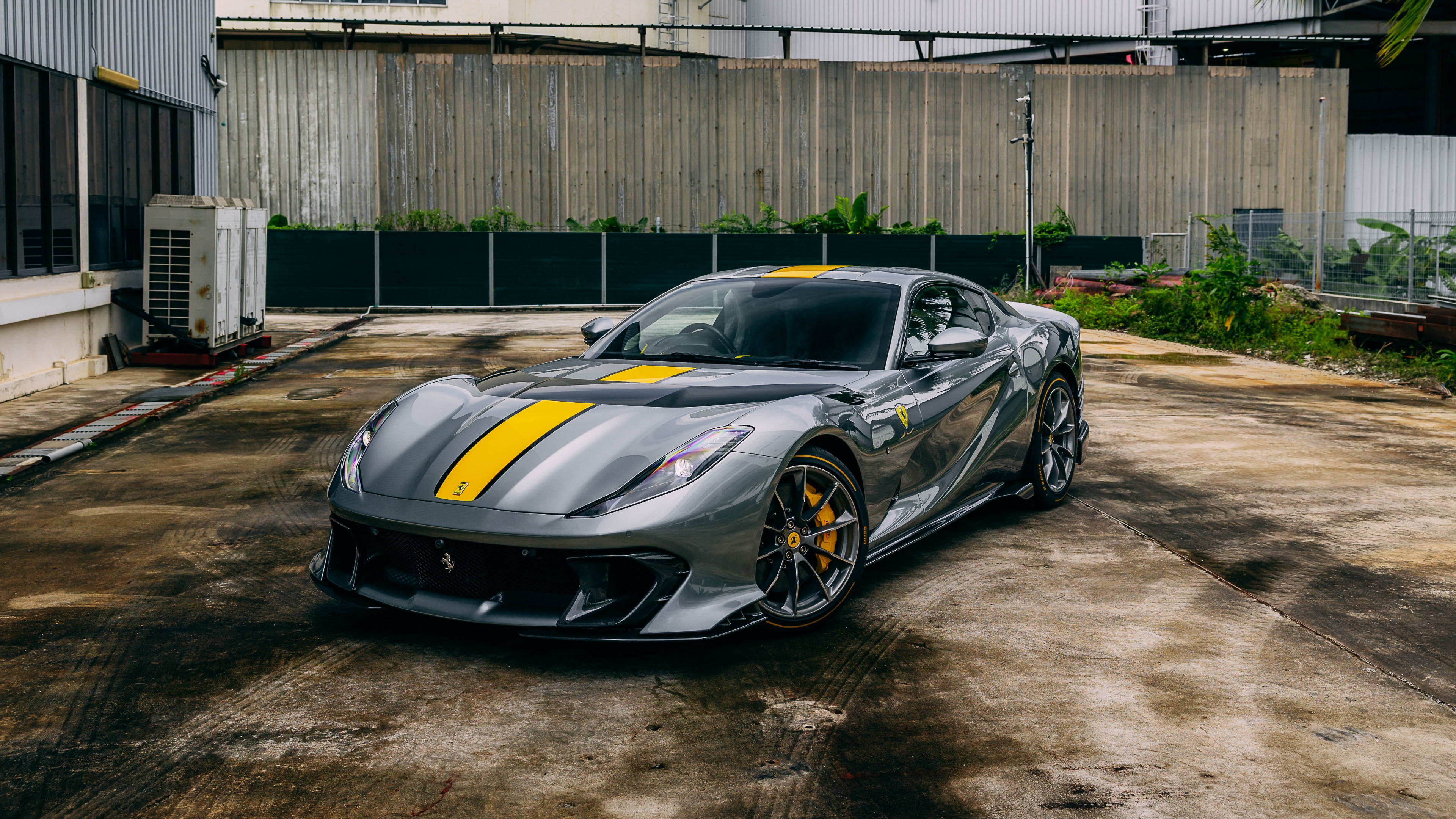 A detailed shot of a Ferrari 812 Competizione sports car parked outdoors.