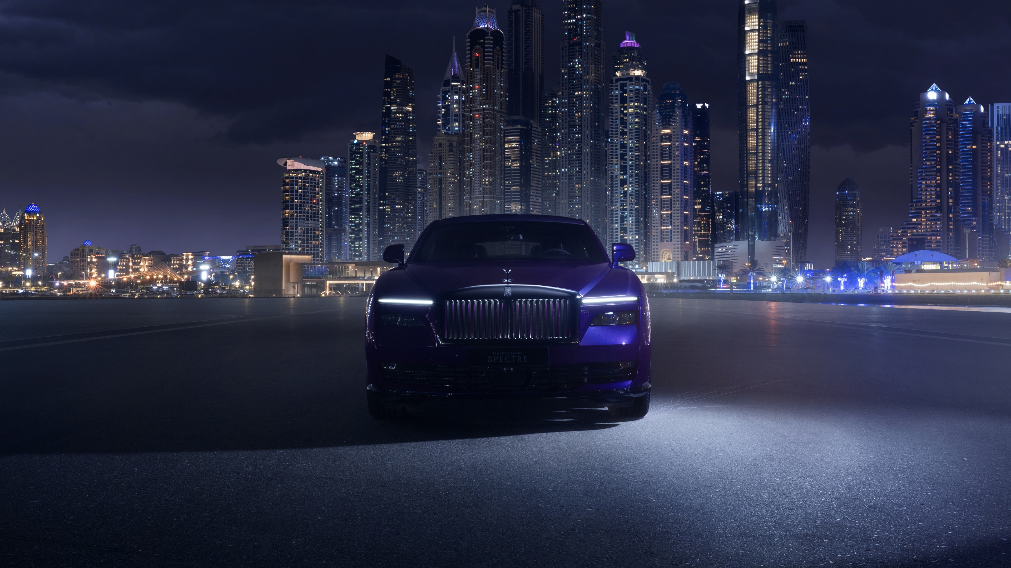 A luxurious Rolls-Royce Black Badge Spectre driving through the neon-lit streets of Dubai at night with a deep purple aesthetic.