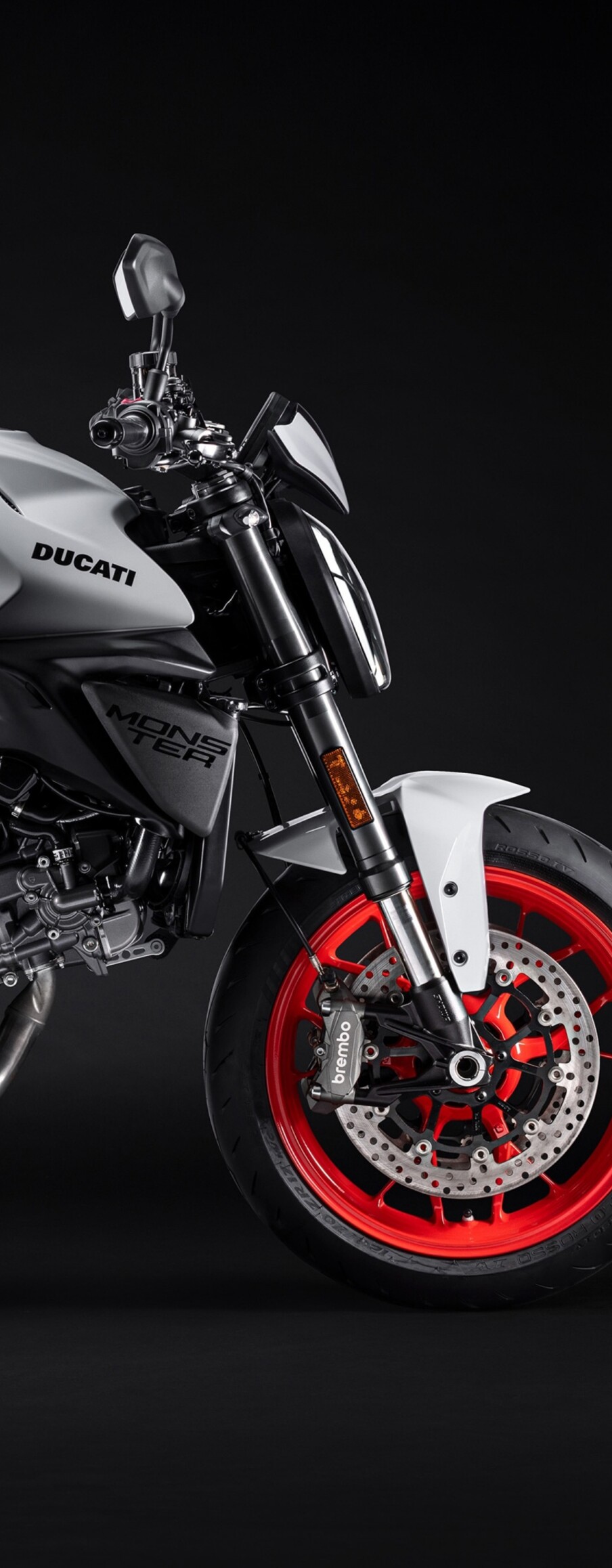A high-resolution, cinematic close-up of a 2026 Ducati Monster V2 motorcycle set against a dark, moody background.