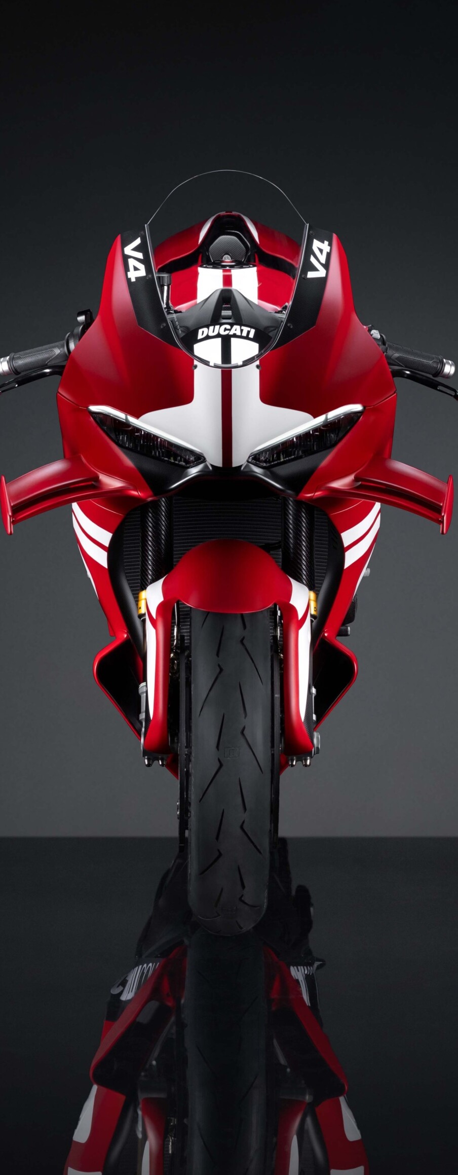 A high-detail, cinematic view of the Ducati Superleggera V4 Centenario 2027 sports motorcycle against a dark, atmospheric background.
