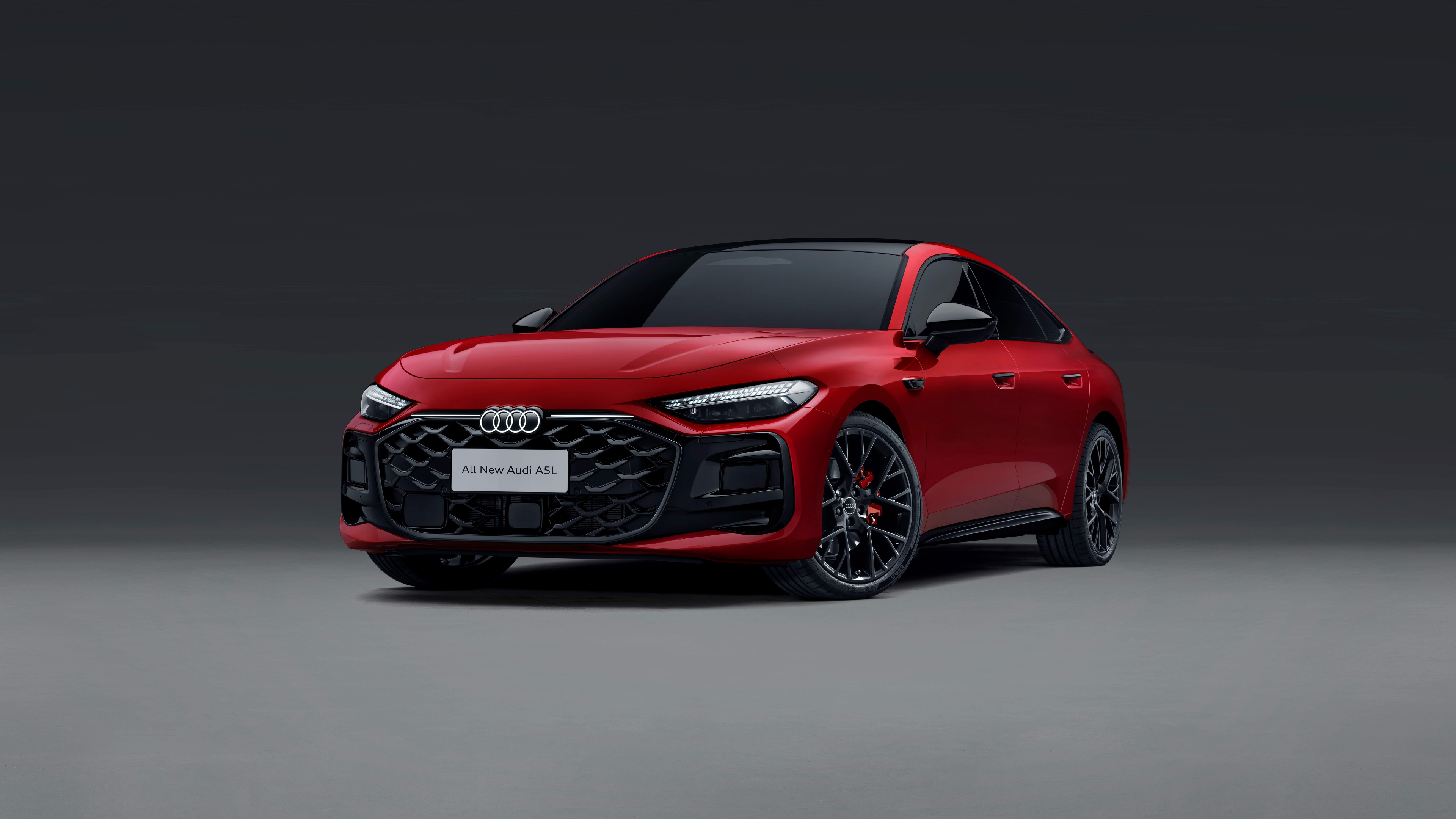 A high-resolution image of a polished red luxury sedan against a solid grey background.