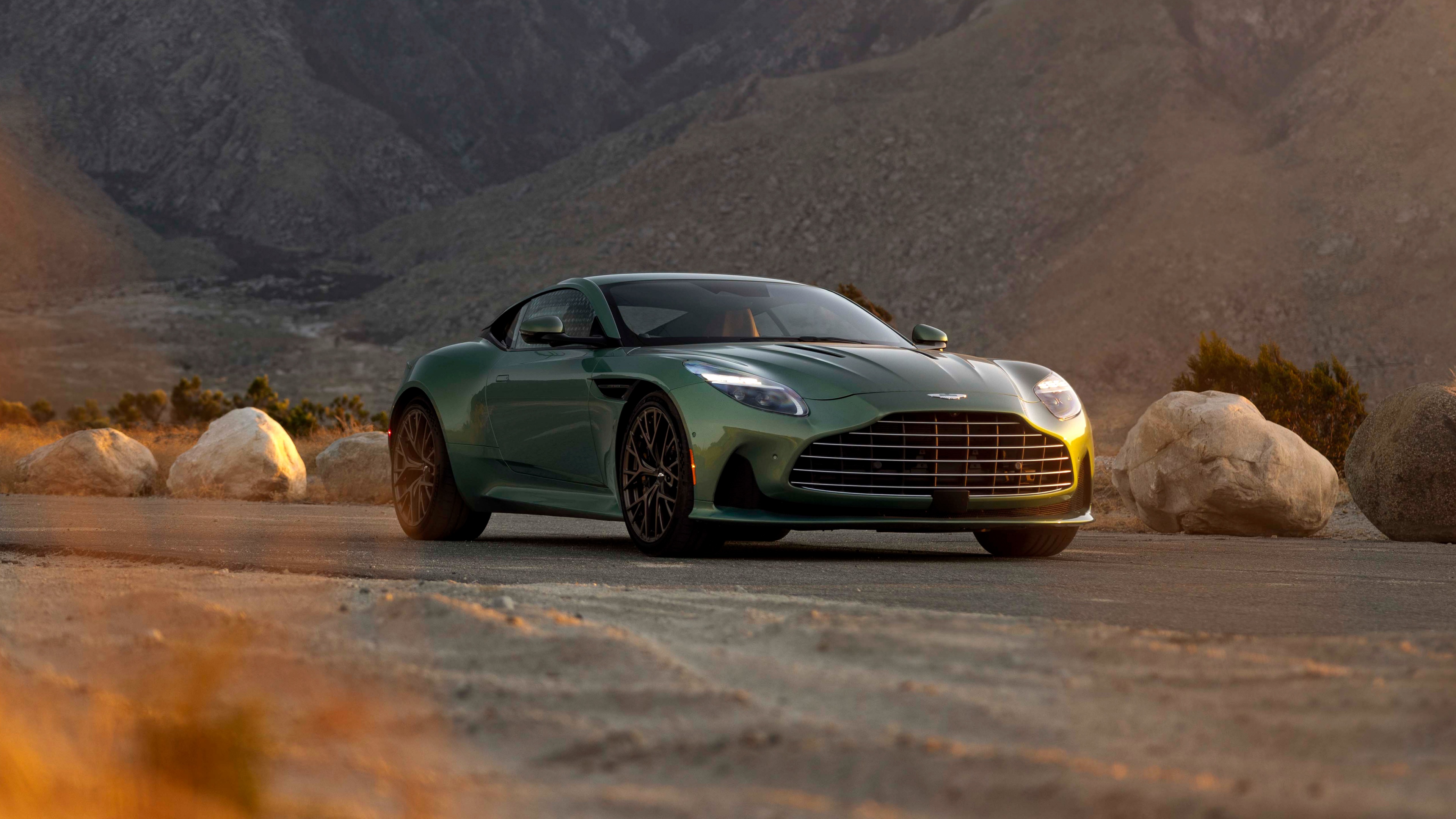 A detailed 5K view of a 2025 Aston Martin DB12 supercar, featuring its iconic front grille and sleek metallic bodywork.