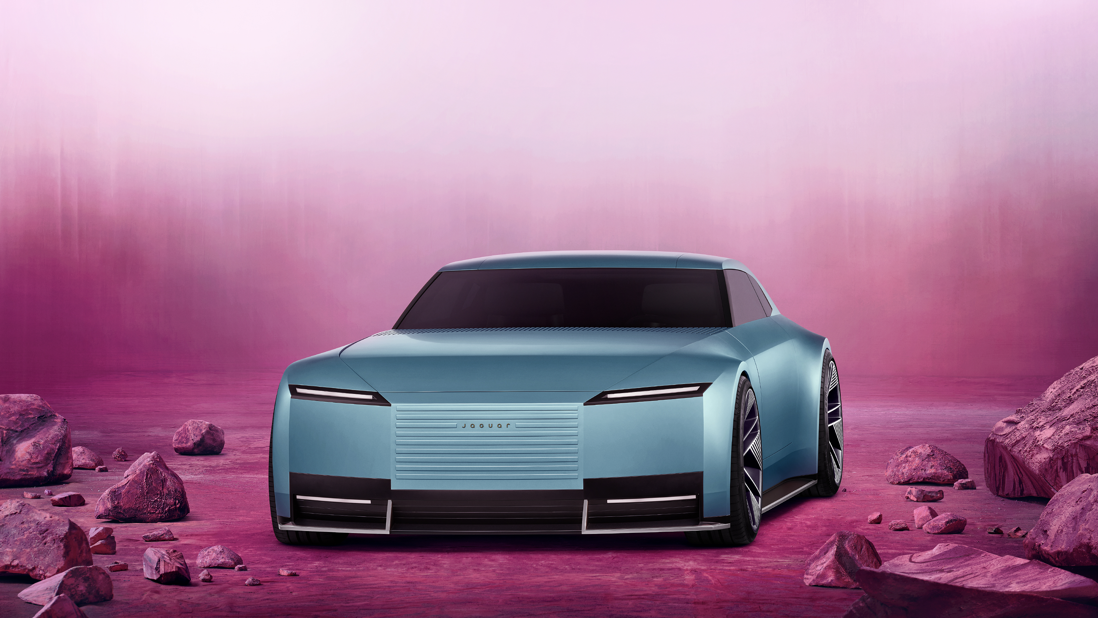 A futuristic Jaguar Type 00 concept car featuring a monochrome pink aesthetic and soft pink background.