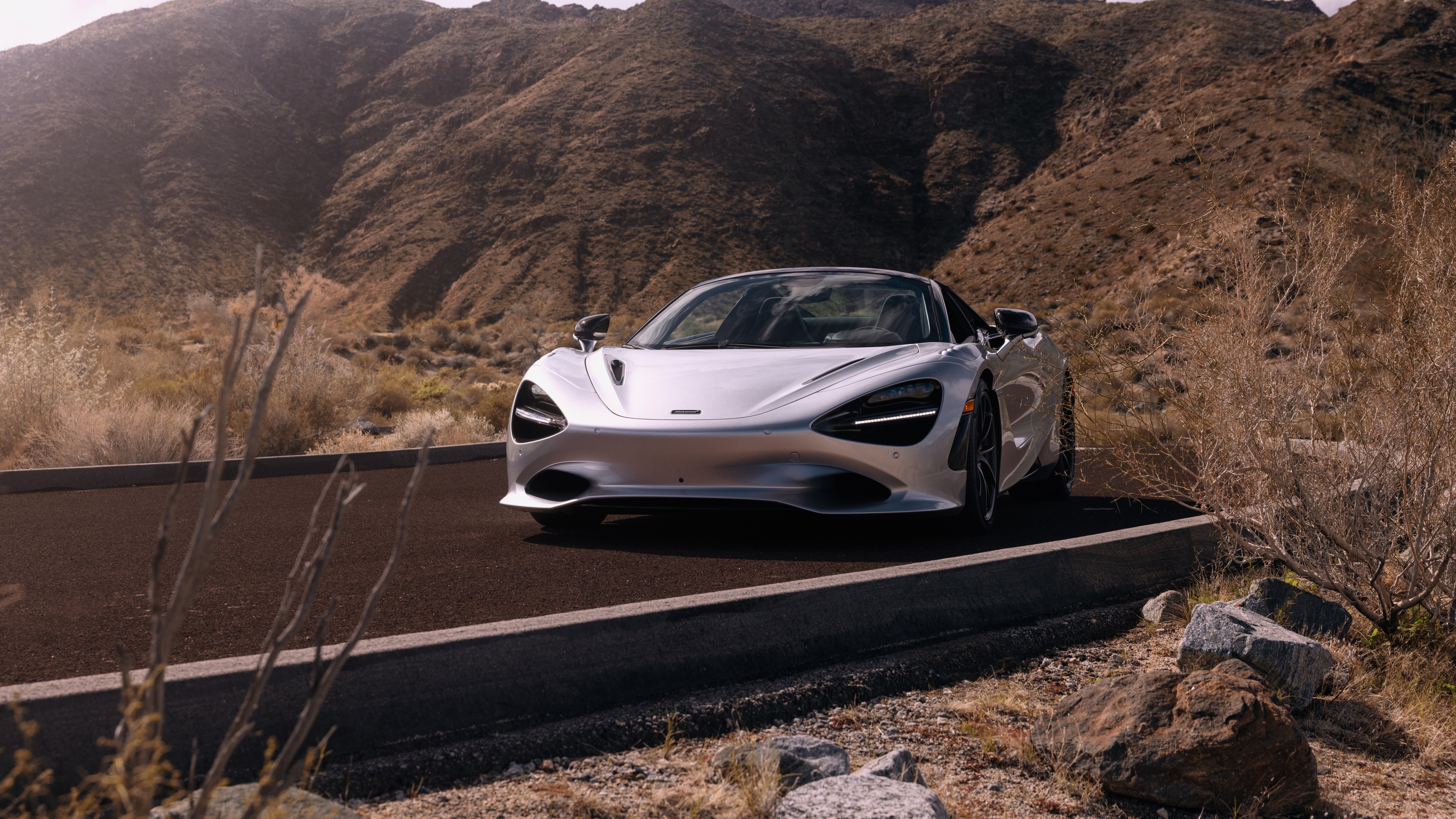 A high-detail shot of a McLaren 750S Spider super car positioned on a dark tarmac surface.