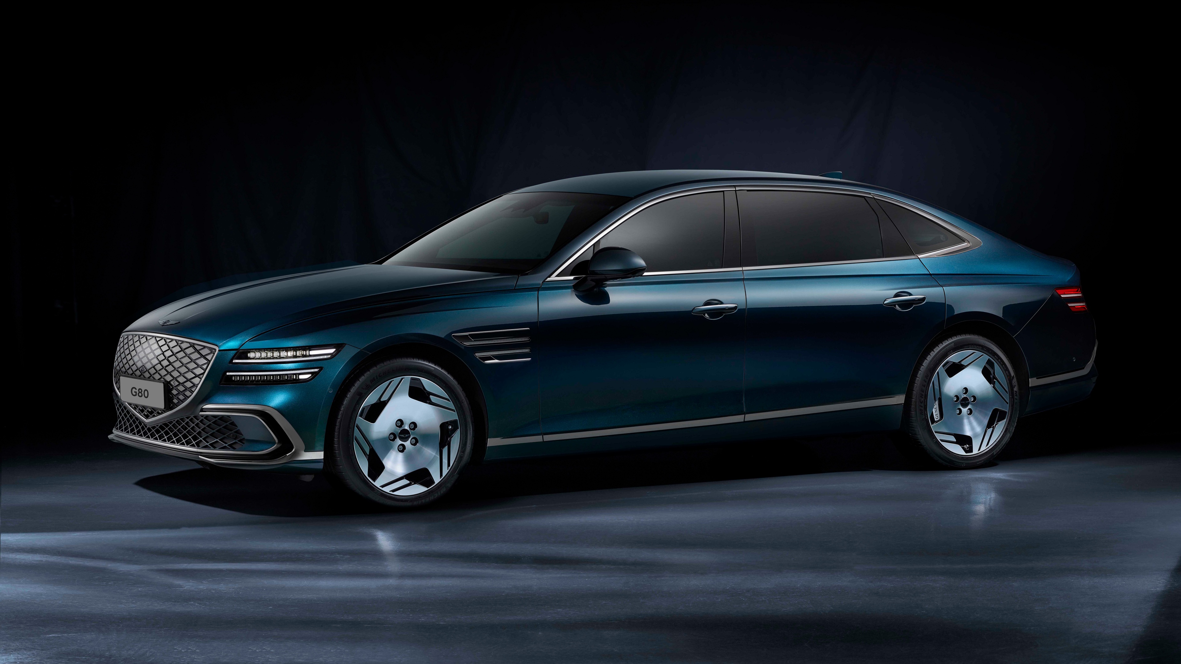 A high-detail, cinematic shot of the Genesis Electrified G80 luxury electric sedan against a dark, atmospheric background.