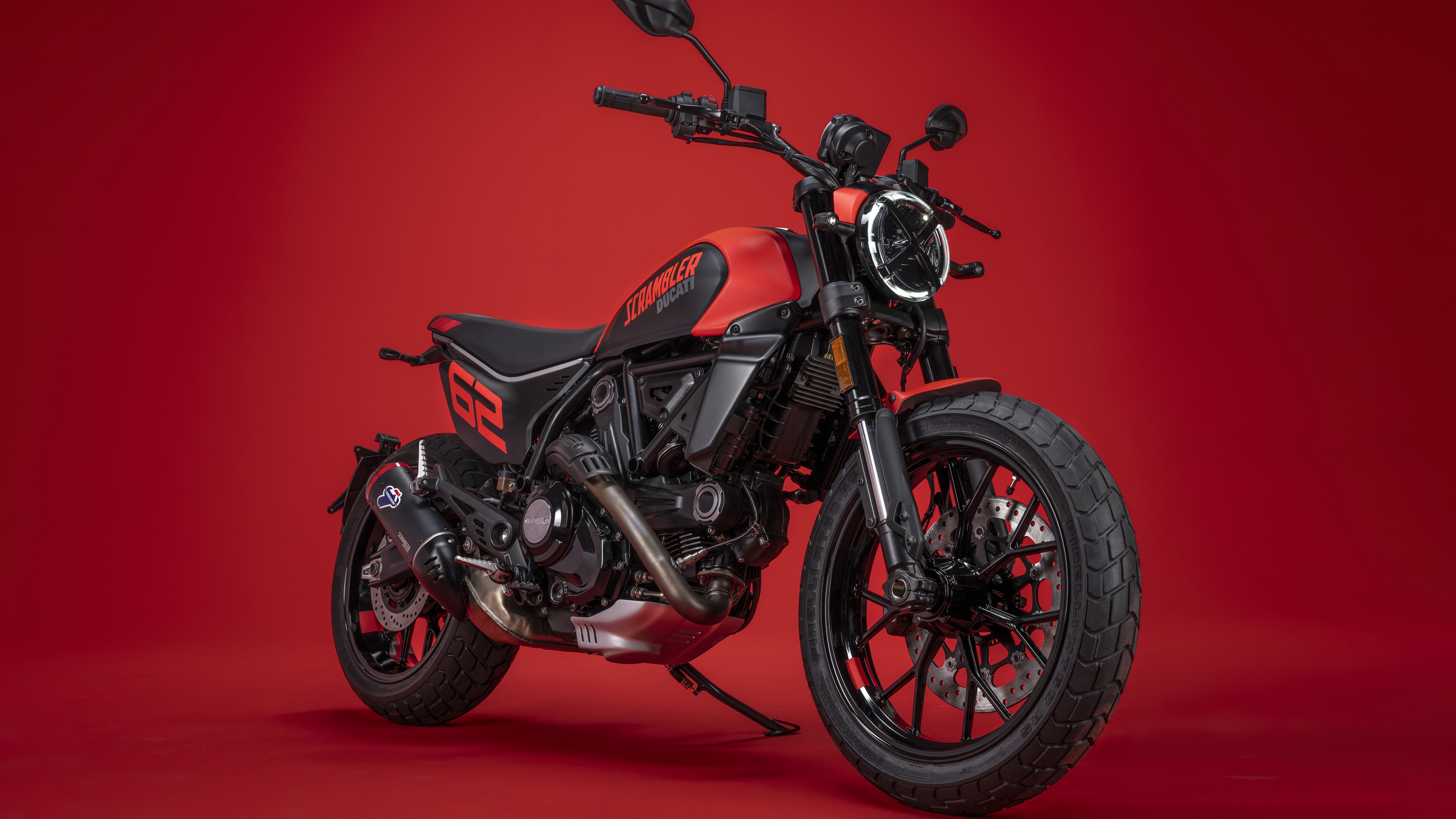 A 2023 Ducati Scrambler Full Throttle motorcycle positioned against a solid, vibrant red background.