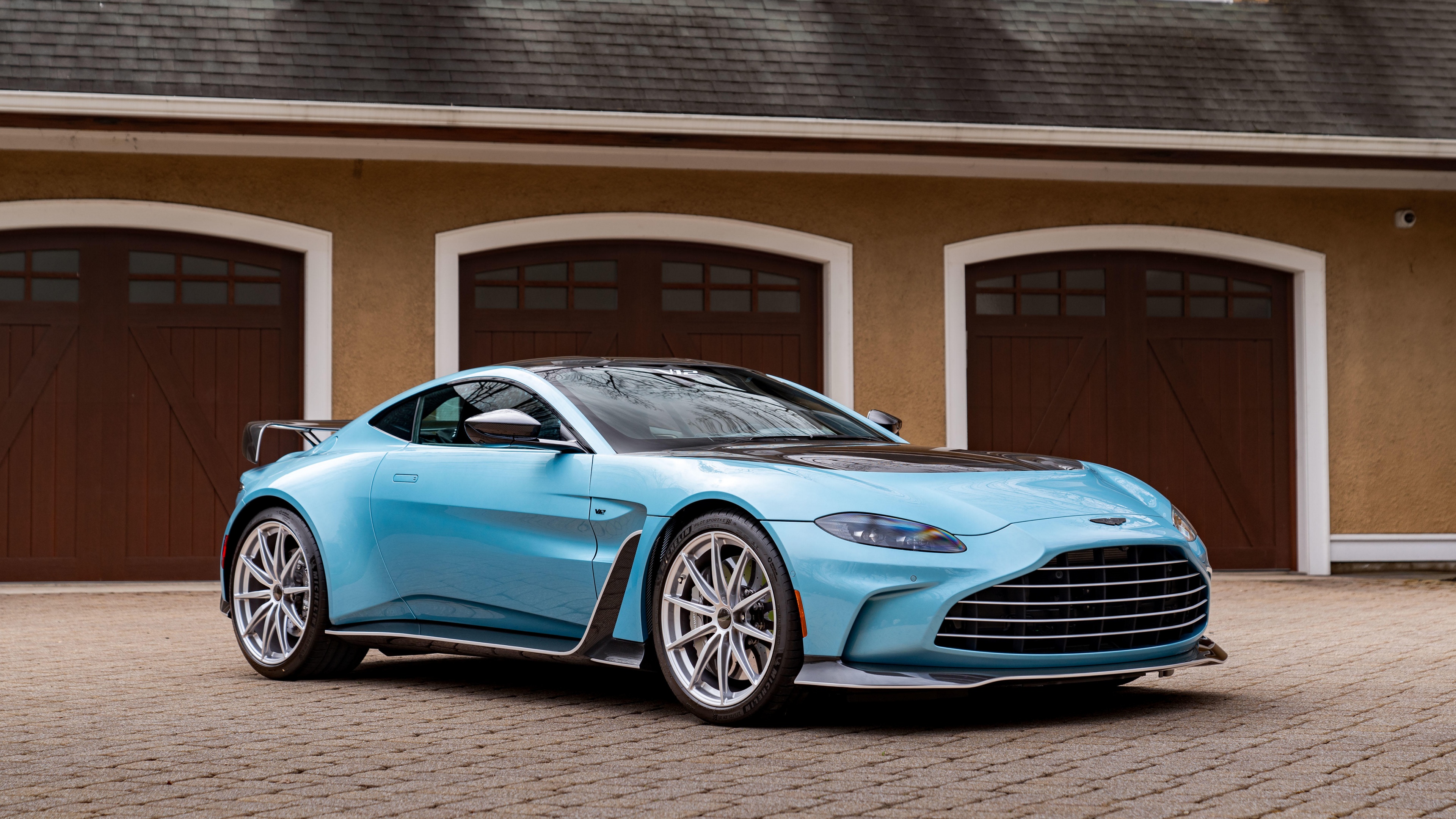 A high-detail 5K shot of the 2024 Aston Martin V12 Vantage sports car showcasing its premium finish and aerodynamic body.