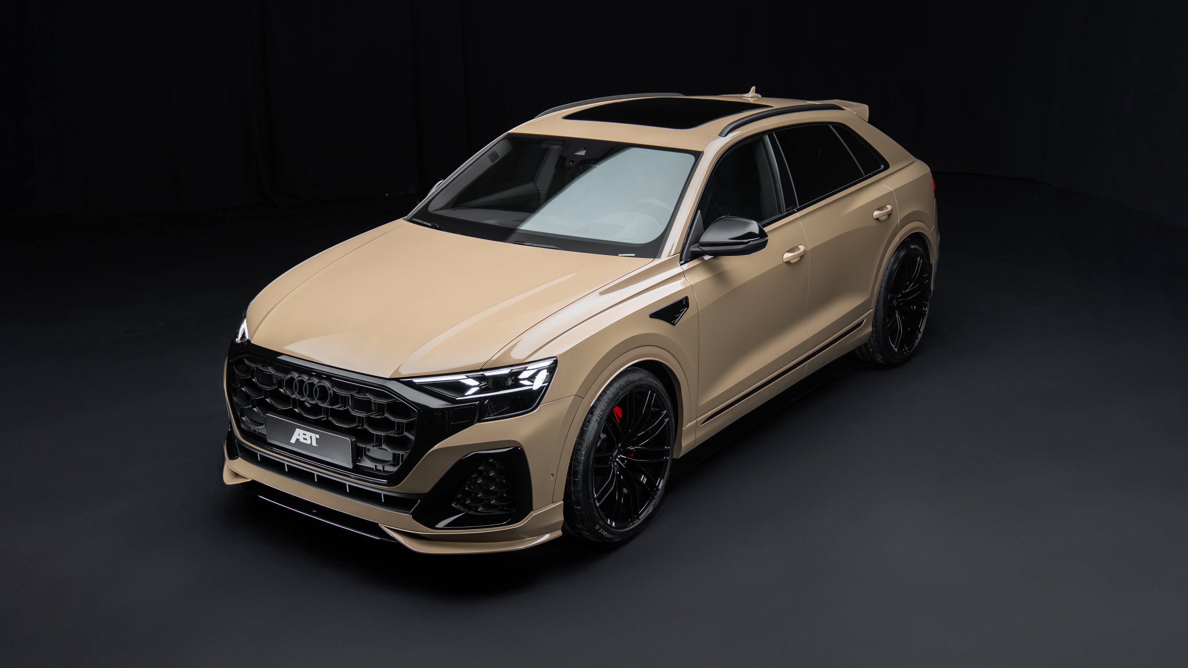 A high-resolution shot of a 2024 Audi Q8 luxury SUV featuring dramatic lighting against a dark, minimalist background.