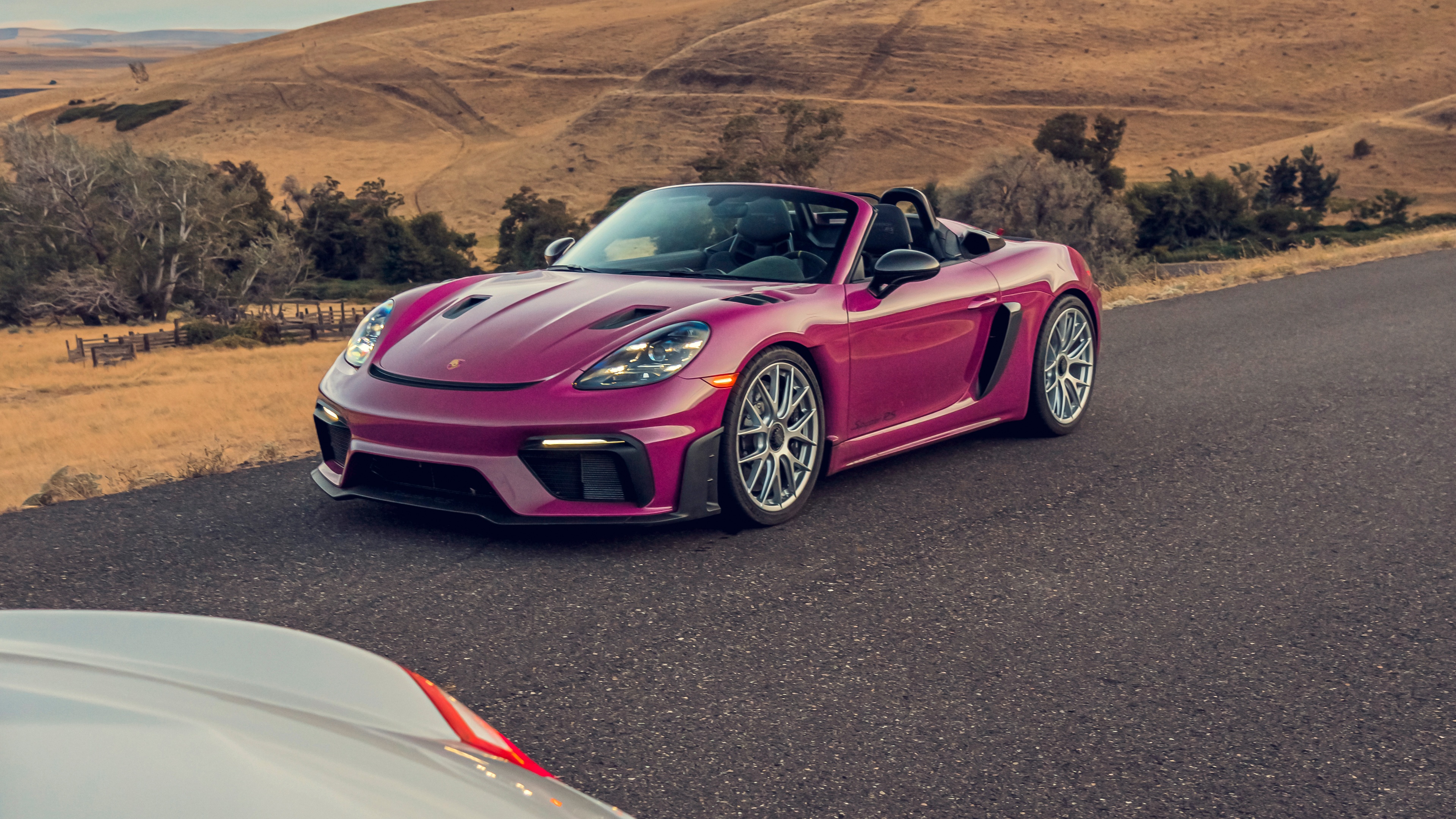 A high-detail, 5K resolution shot of the 2024 Porsche 718 Spyder RS showcasing its aerodynamic design and sleek profile.