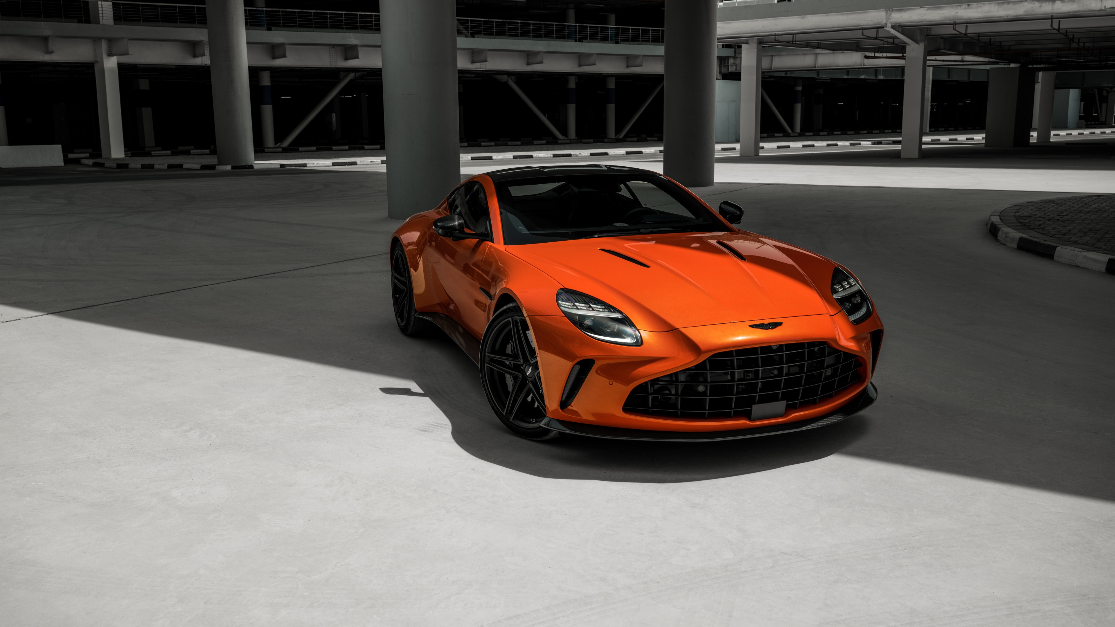 A vibrant orange 2025 Aston Martin Vantage luxury sports car shown in high detail.