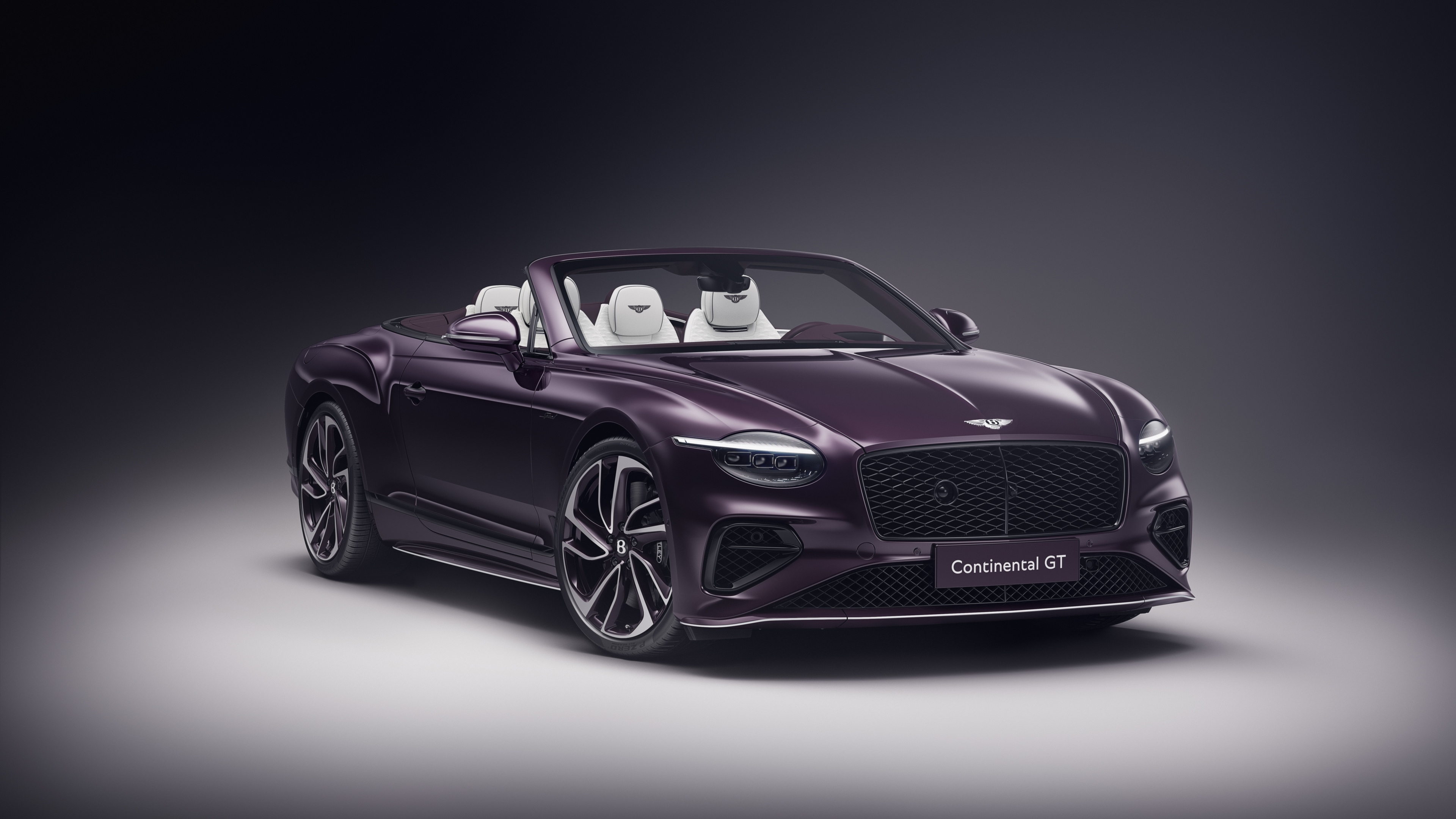 A luxurious 2025 Bentley Continental GT Mulliner Convertible featuring a deep purple aesthetic and elegant lighting.