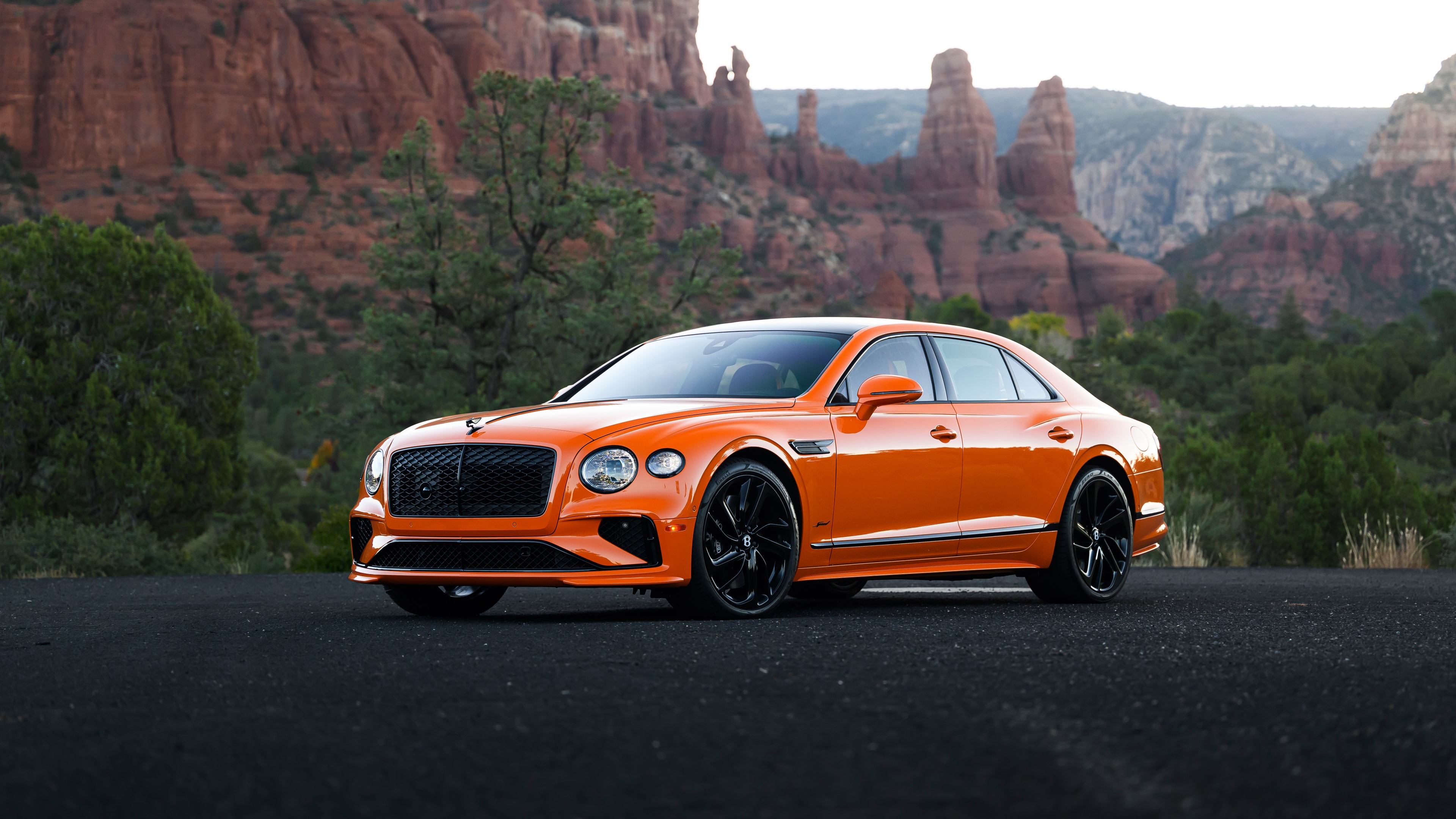 A high-resolution, close-up view of a vibrant orange 2025 Bentley Flying Spur Speed luxury sedan.