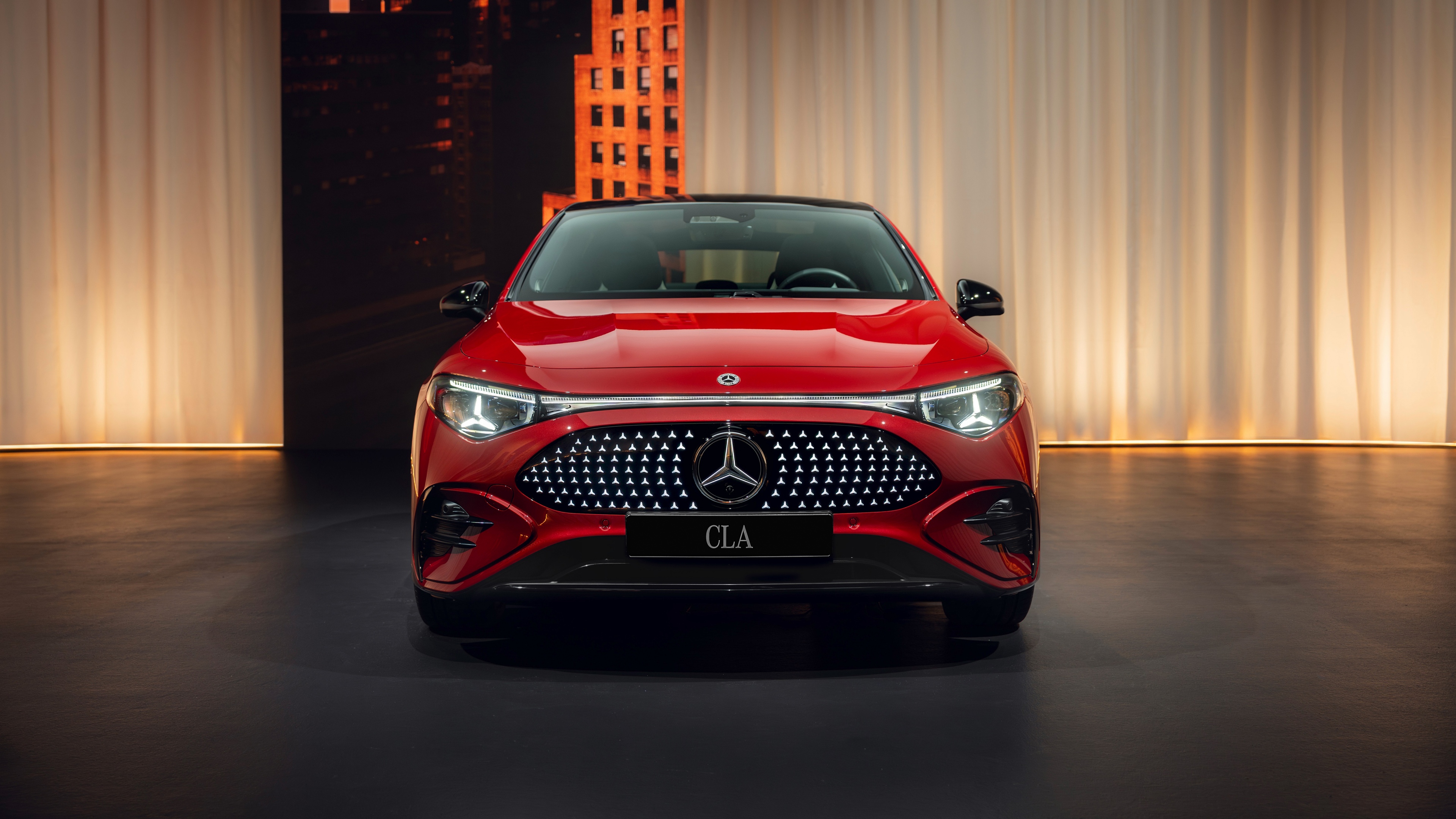 A sleek and glossy red 2025 Mercedes-Benz CLA 350 4MATIC with AMG line styling.