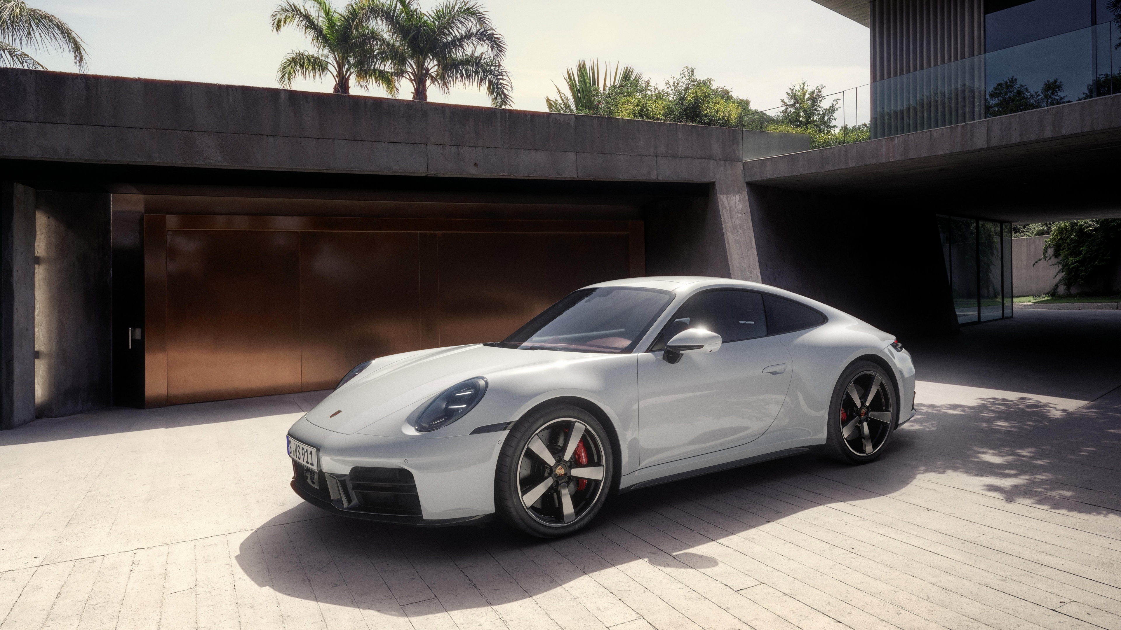 A pristine white 2025 Porsche 911 Carrera S featuring a sleek and aerodynamic modern design.