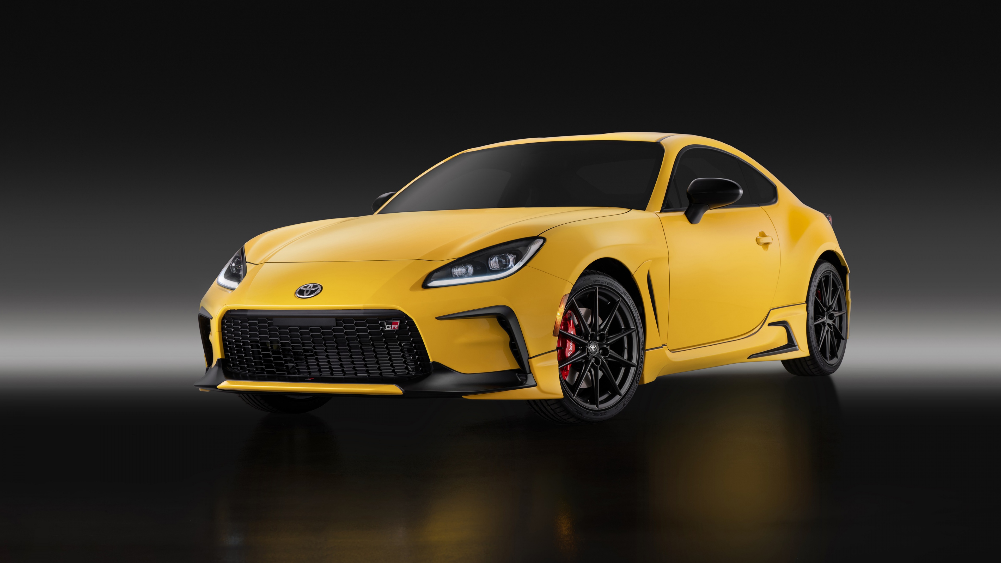 A high-resolution, cinematic shot of a 2026 Toyota GR 86 sports car against a dark, minimalist background.