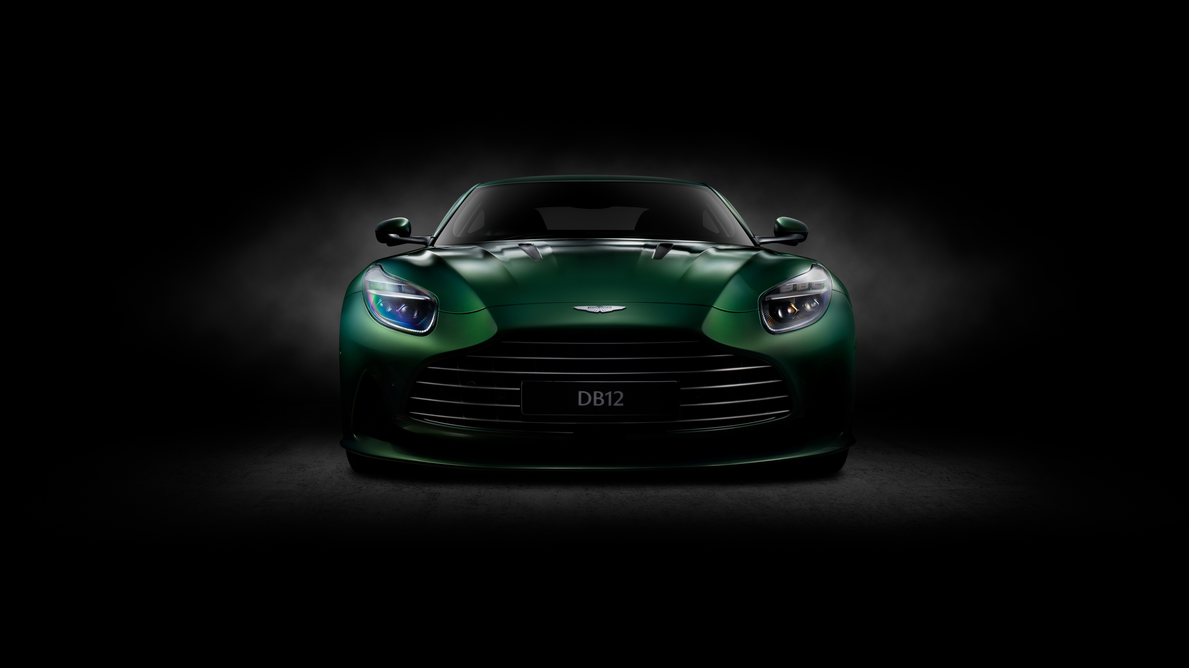 A cinematic, high-detail shot of a sleek Aston Martin DB12 sports car against a dark, moody background.
