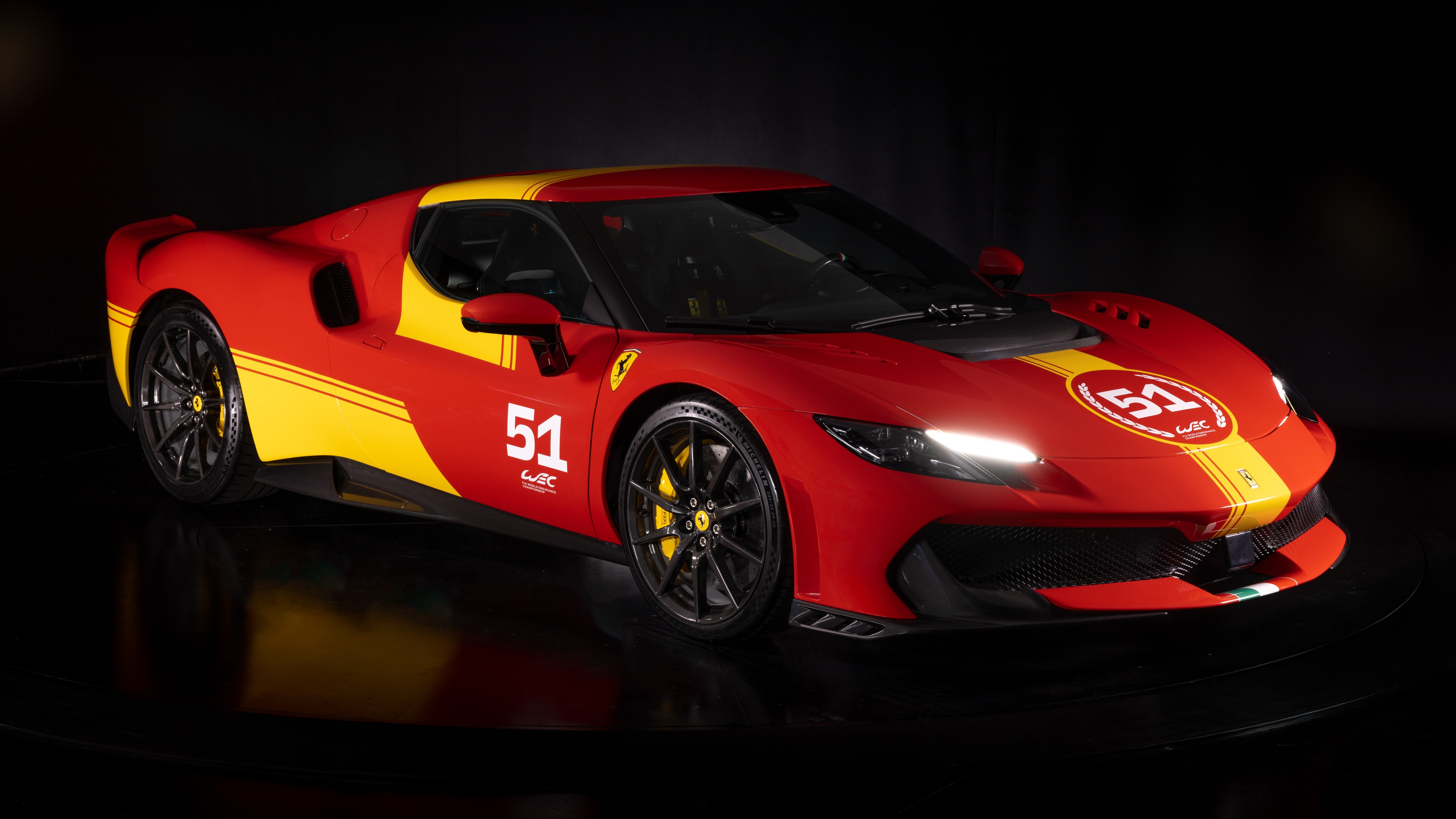 A group of glossy red sports cars positioned against a dark, dramatic background with cinematic lighting.