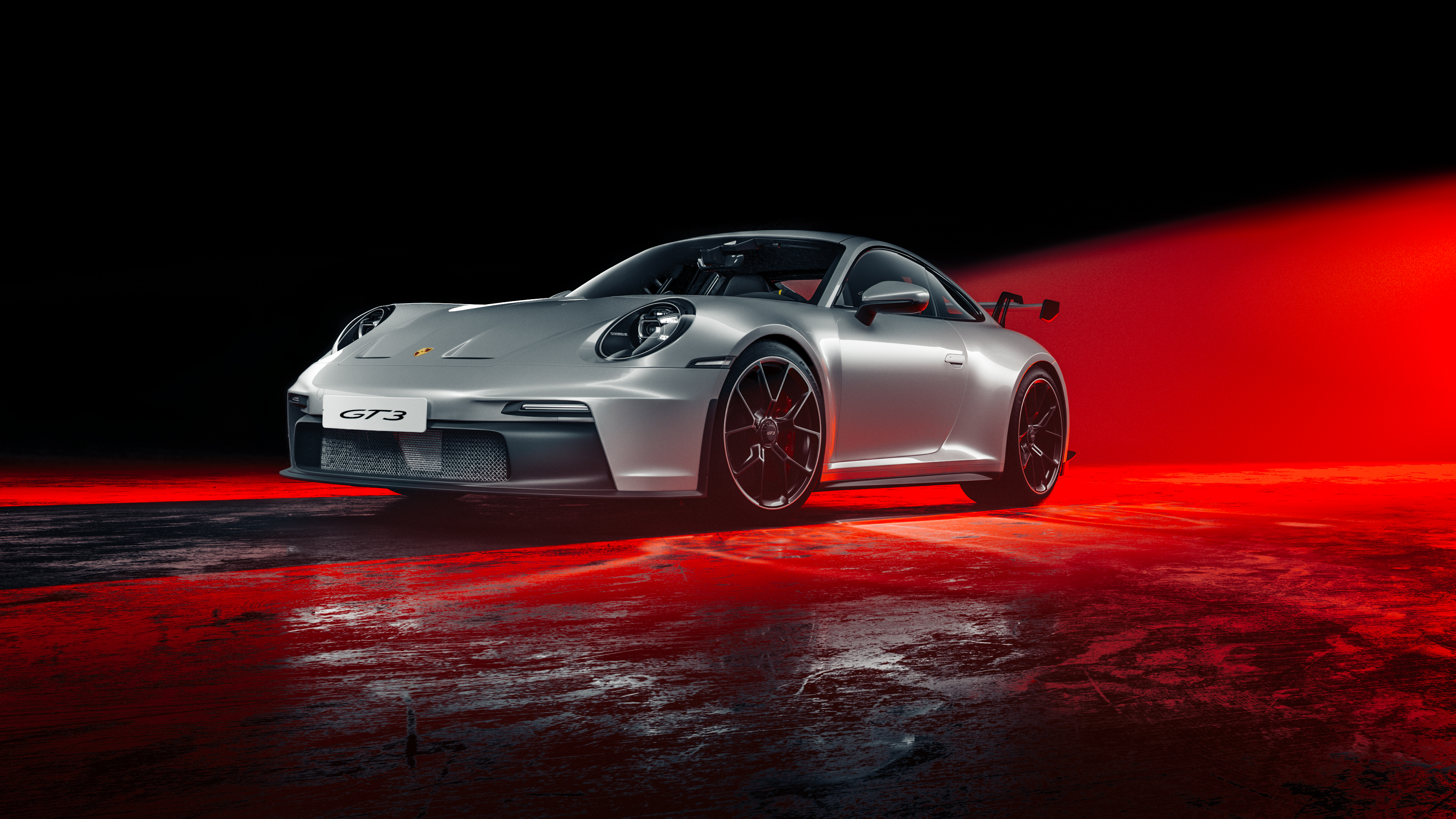 A high-performance Porsche 911 GT3 positioned under dramatic red neon lighting.