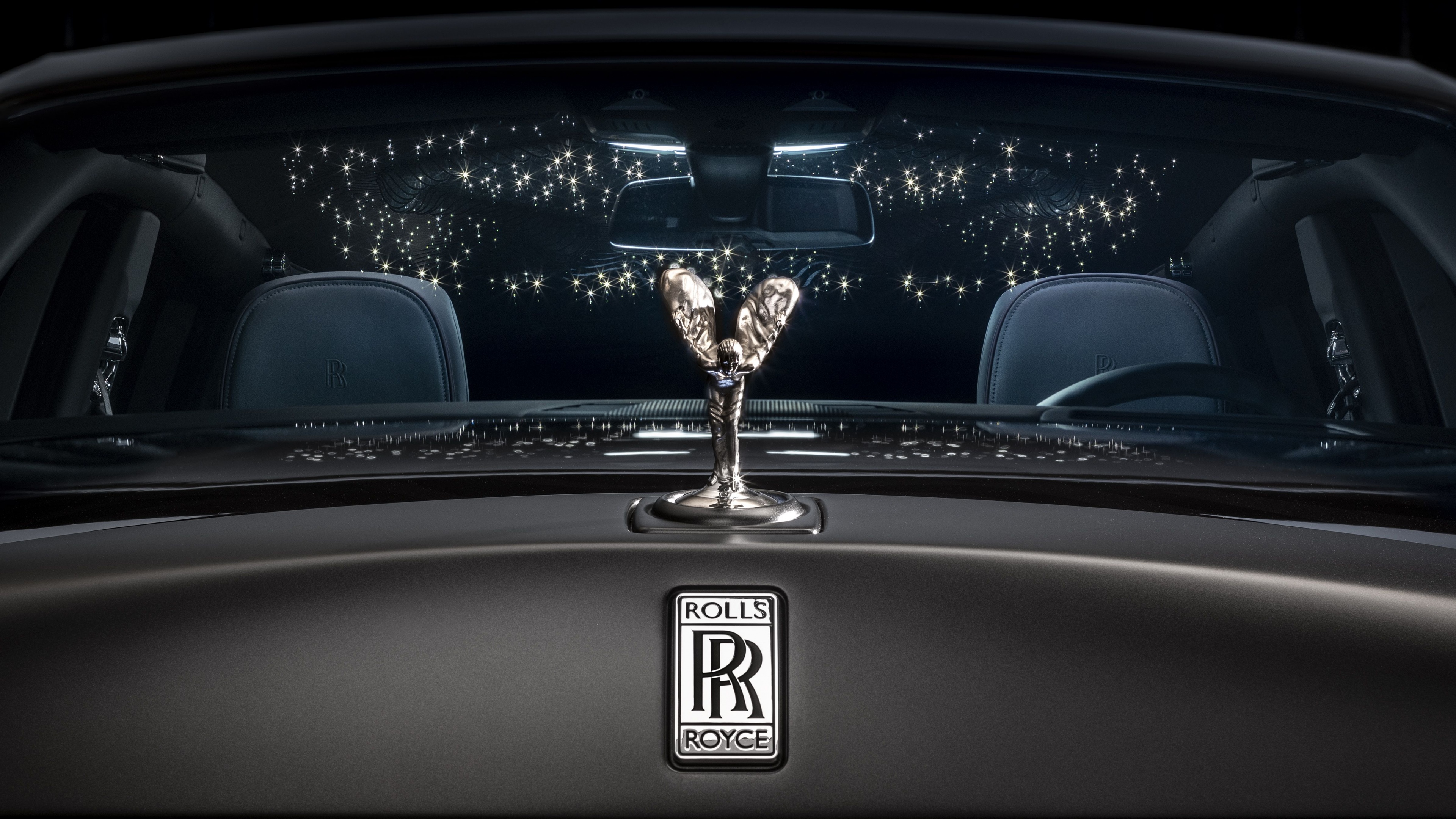A high-resolution close-up of the Rolls-Royce Phantom's Spirit of Ecstasy ornament against a dark, moody background.