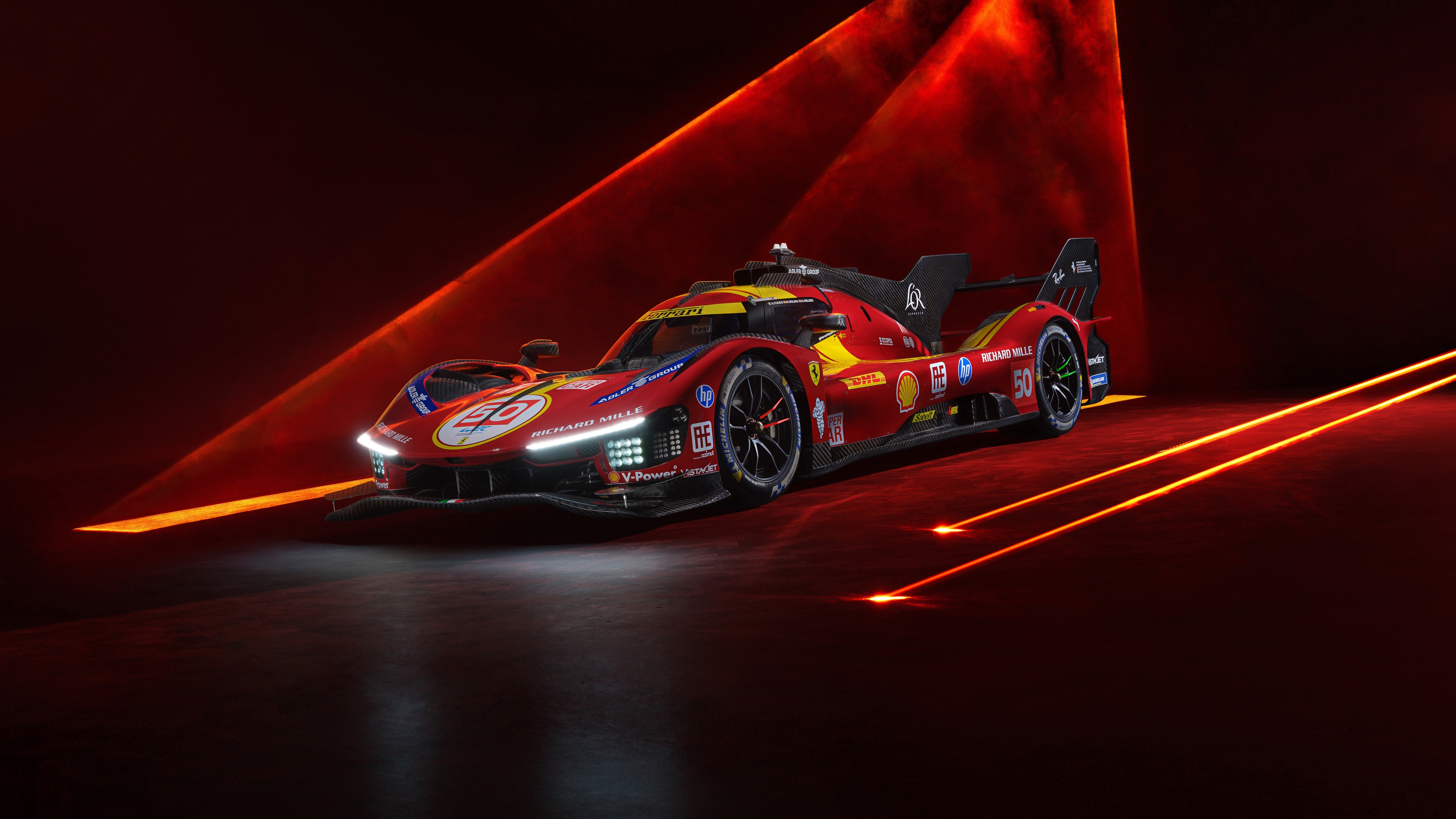 A detailed shot of a red Ferrari 499P Le Mans Hypercar featuring a vibrant red aesthetic and aerodynamic racing design.