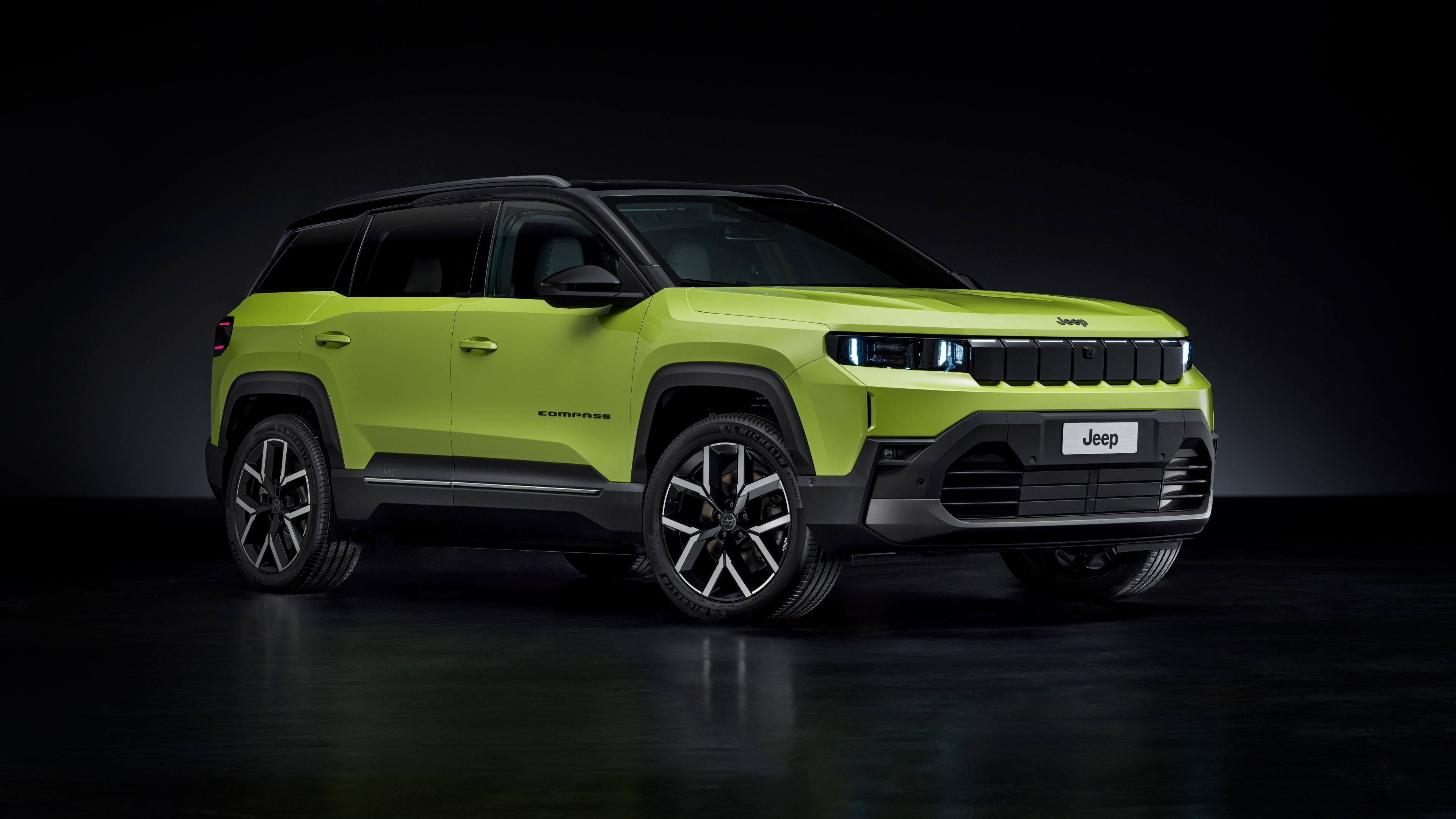 A high-resolution, cinematic studio shot of the Jeep Compass e First Edition electric SUV against a dark, minimalist background.