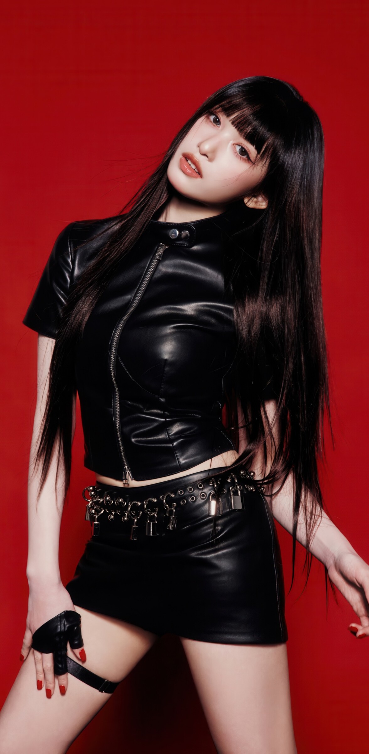 Leeseo from the K-pop group IVE wearing a stylish black dress against a deep red backdrop