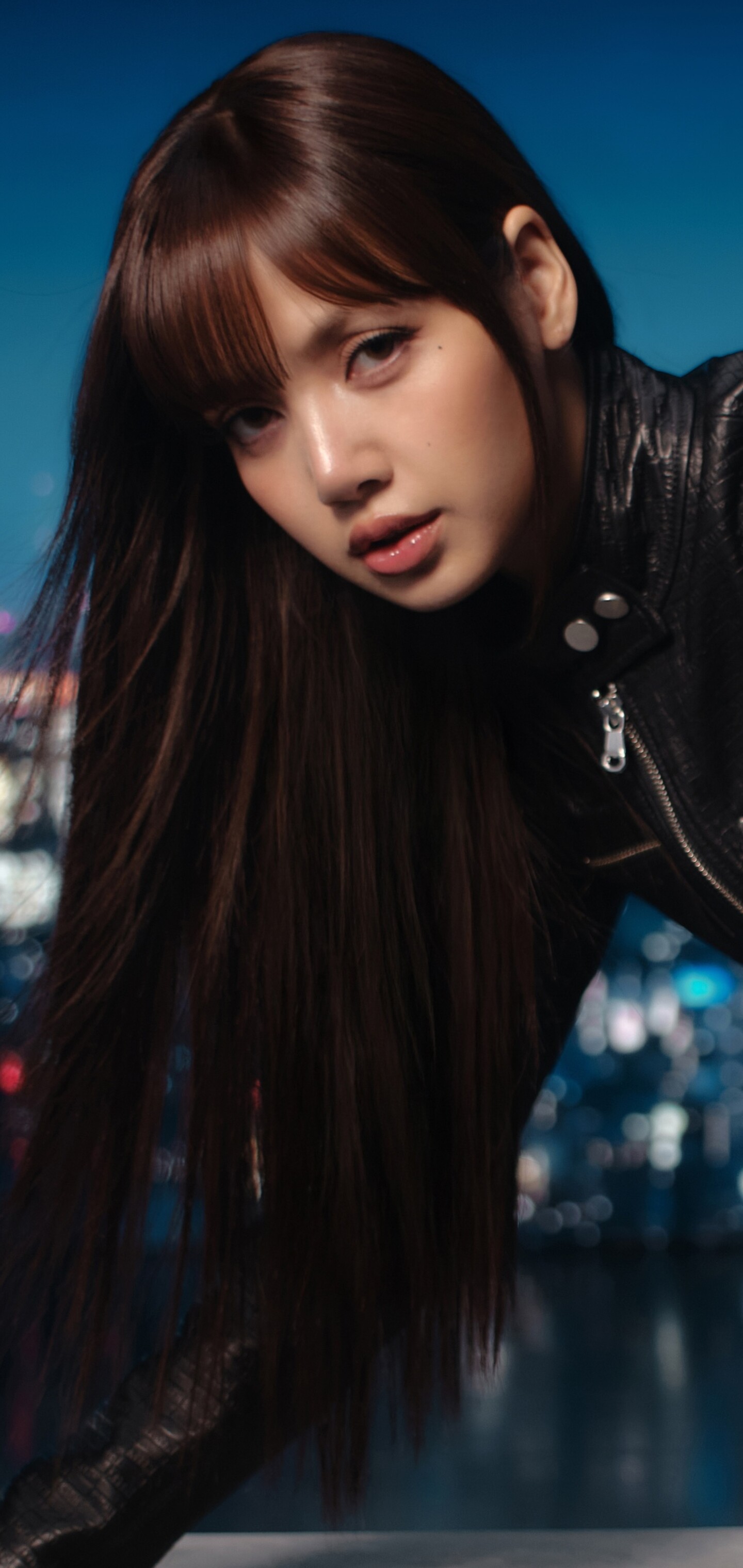 Lisa of Blackpink standing in a neon-lit urban street at night with a cinematic atmosphere.