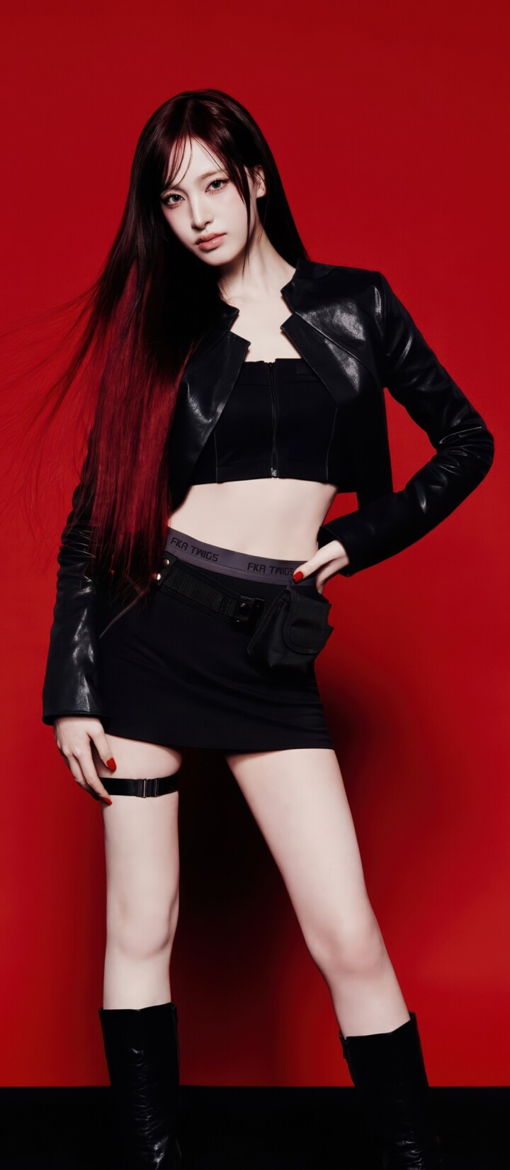 Liz from the K-pop group IVE wearing a stylish black dress against a bold red background.