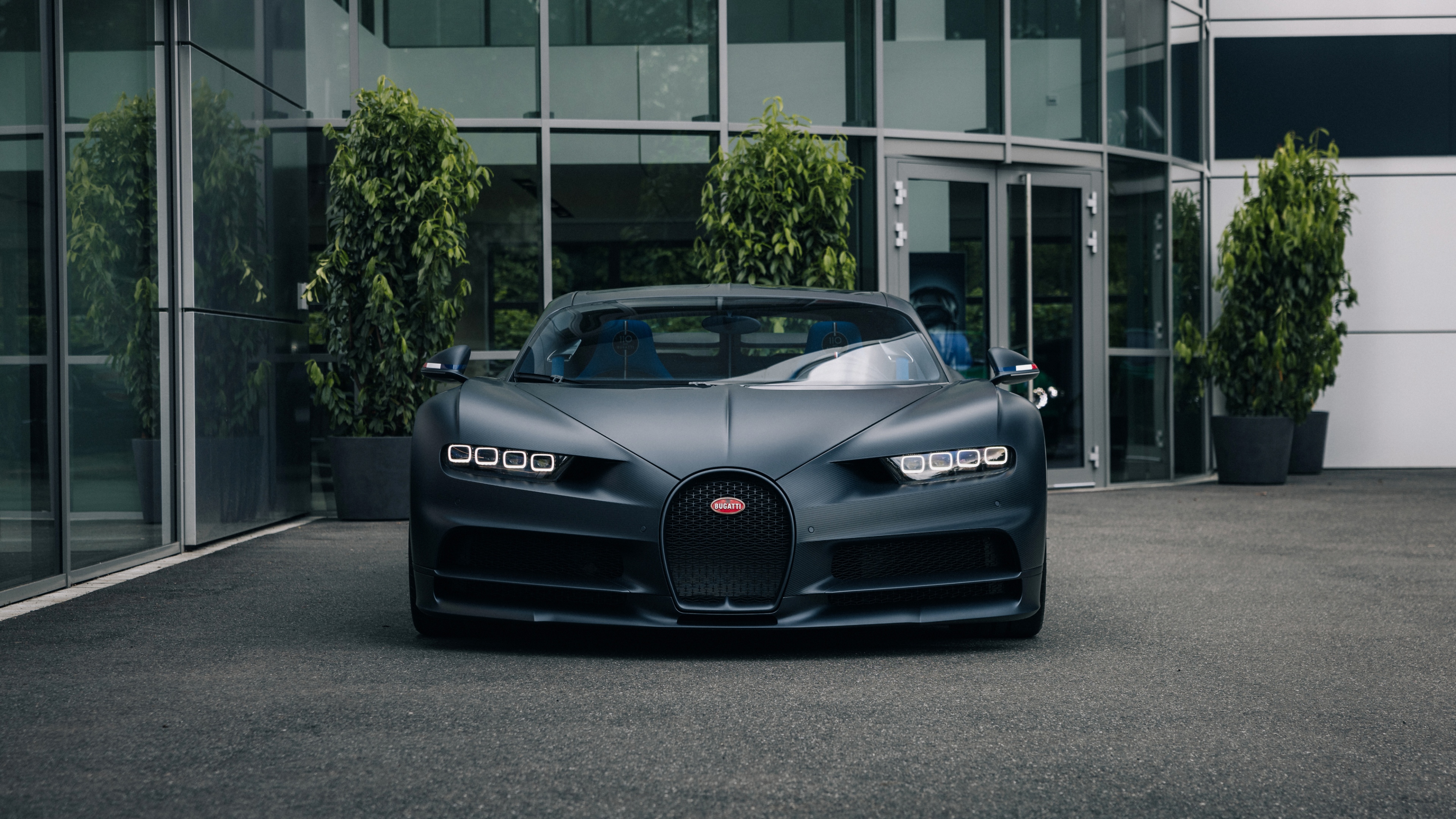 A matte black Bugatti Chiron Sport luxury hypercar parked on a city street.
