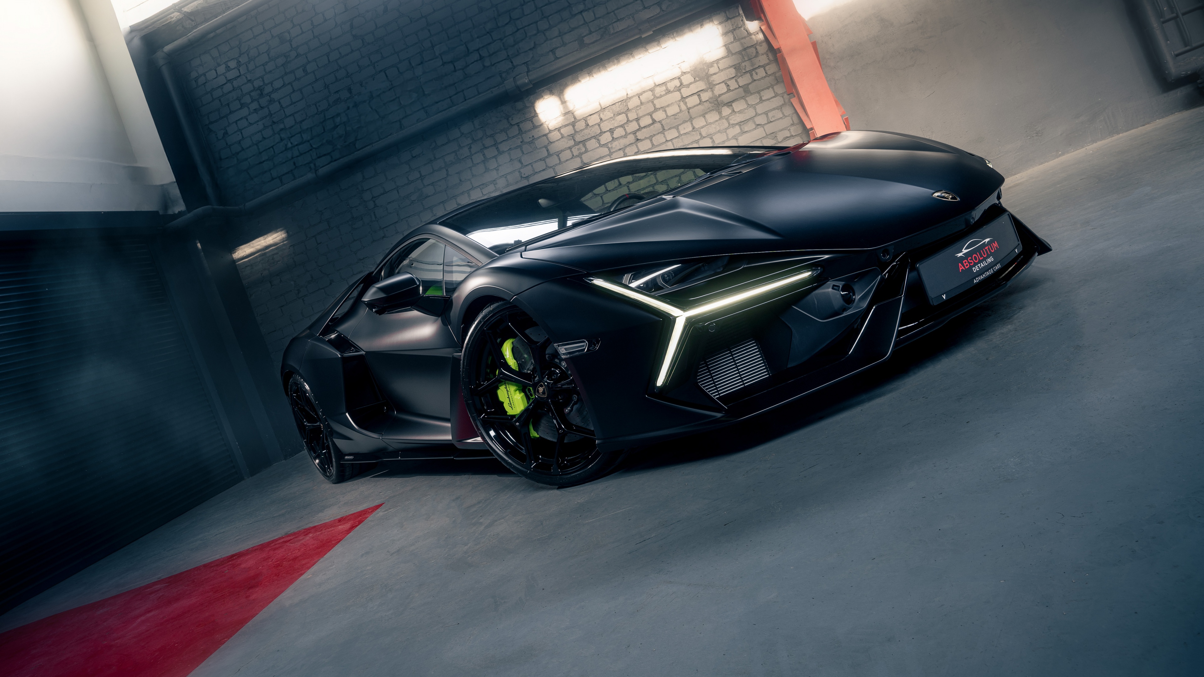 A matte black Lamborghini Revuelto parked in a dark, minimalist luxury garage.
