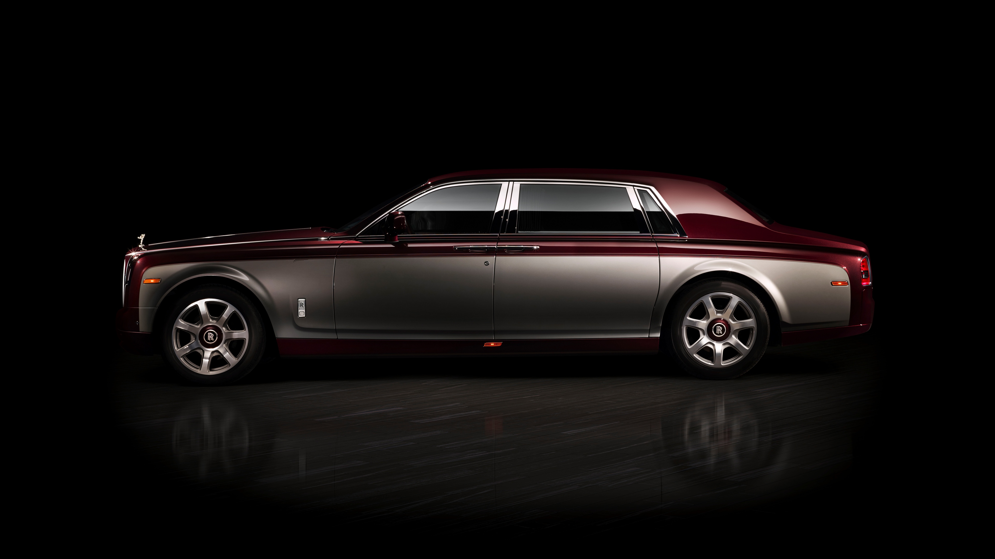 A high-resolution, cinematic shot of a luxury Rolls-Royce Phantom sedan set against a solid black background.