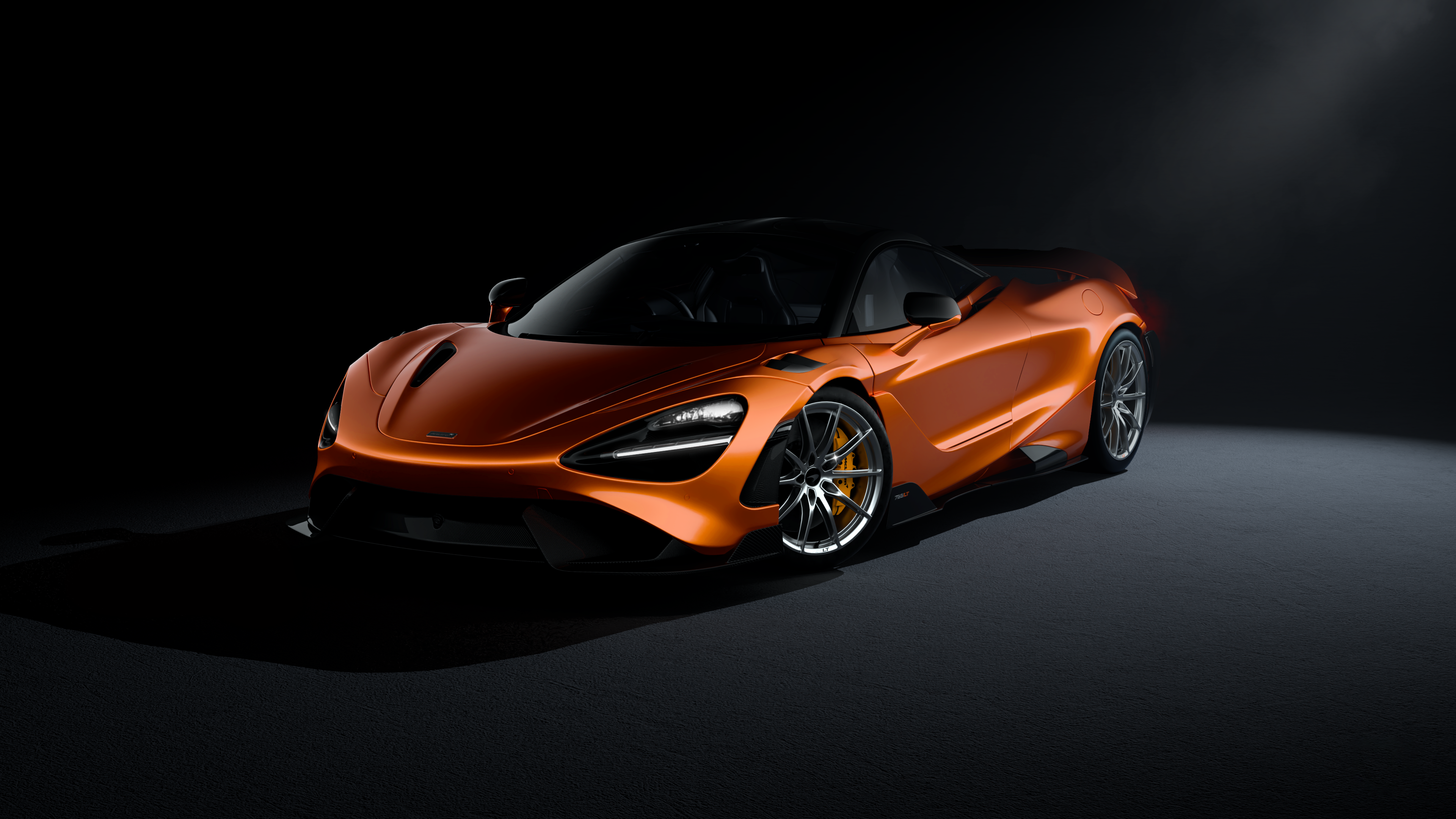 A sleek McLaren 720S supercar captured in a dark, moody aesthetic with dramatic lighting highlighting its contours.