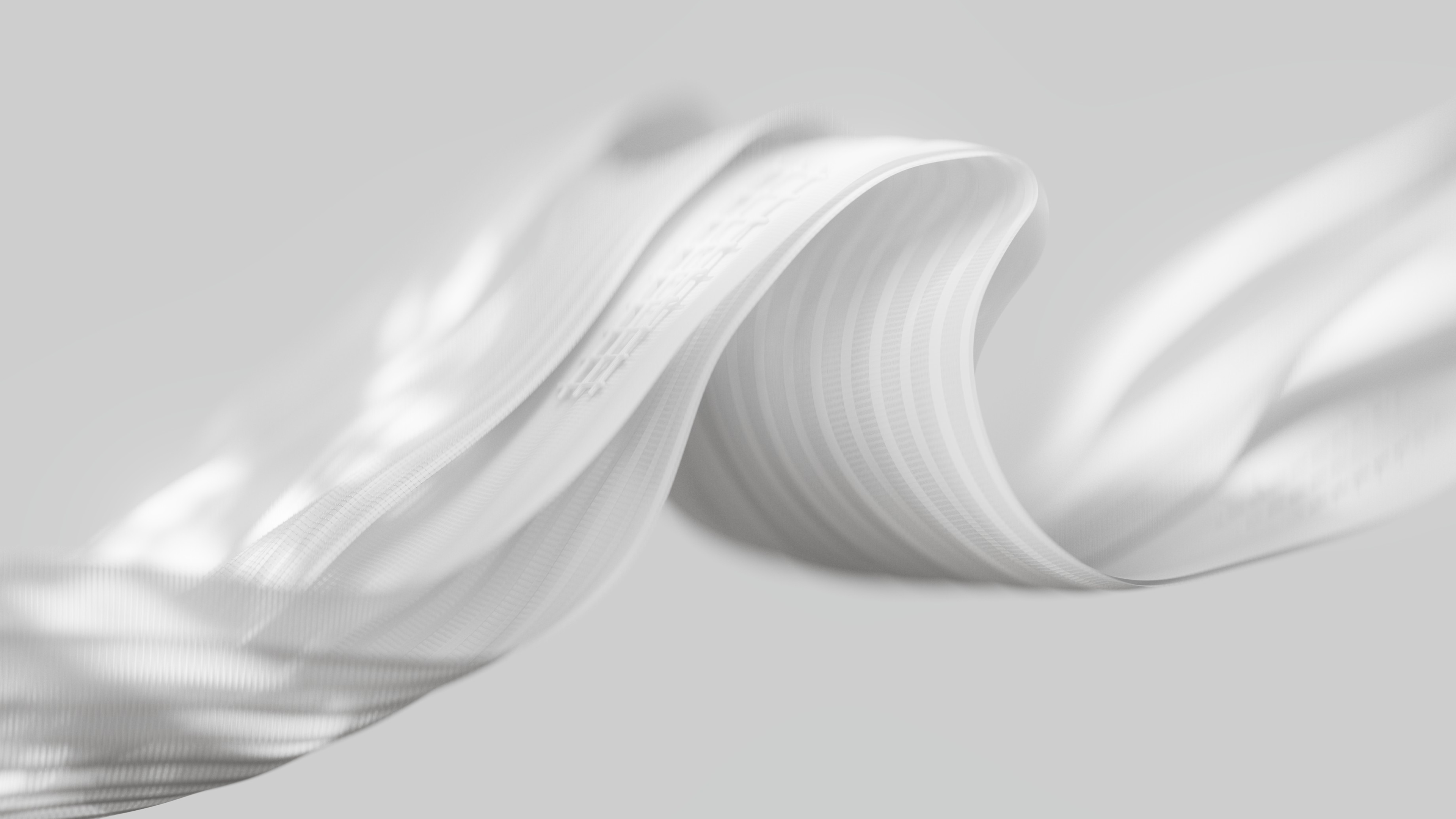 A high-quality, minimalist close-up of flowing white fabric and monochromatic ribbons in a luxury light mode design.