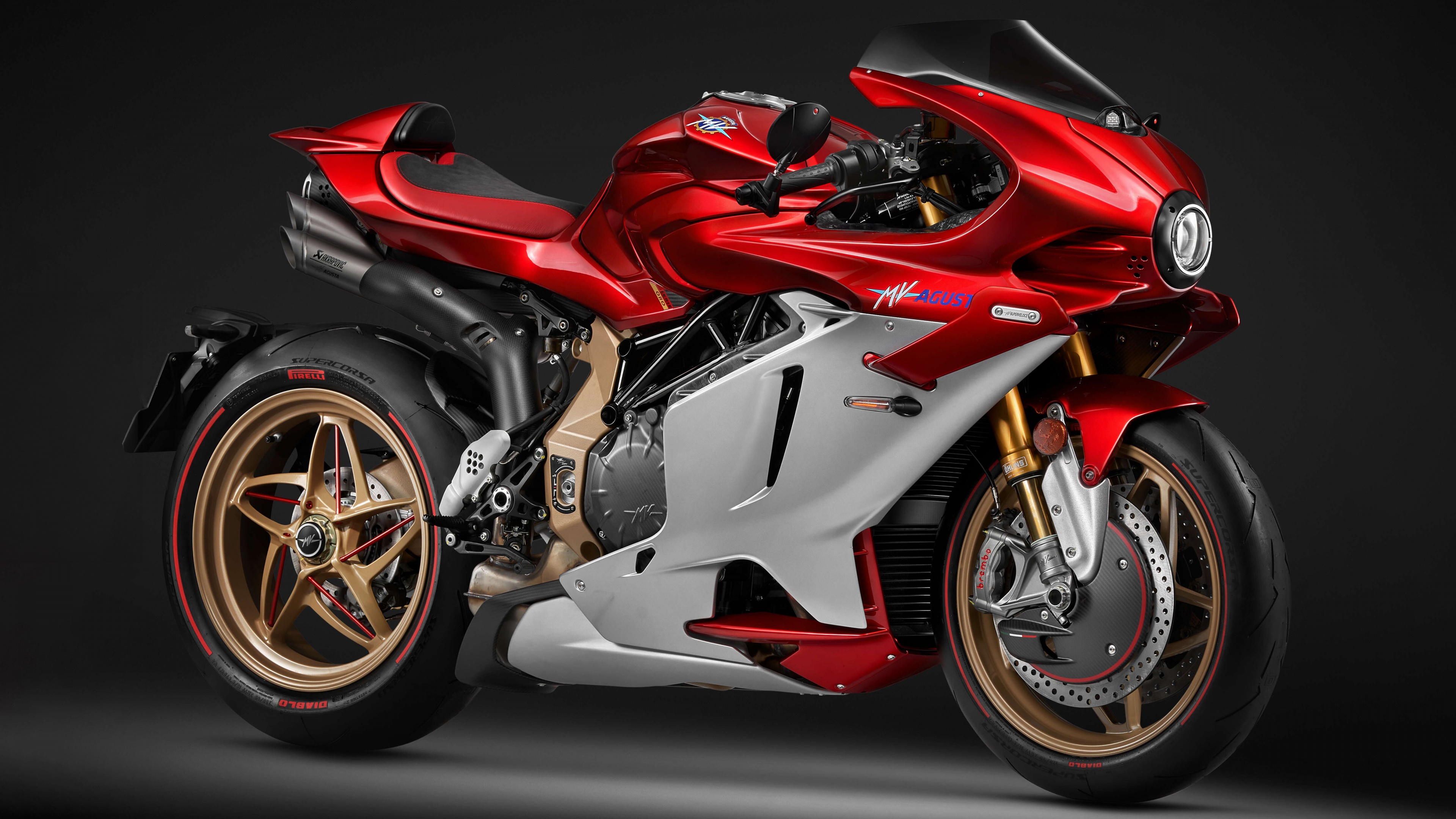 Close-up of the MV Agusta Superveloce 1000 Serie Oro sports motorcycle in a dark studio setting, featuring gold accents.