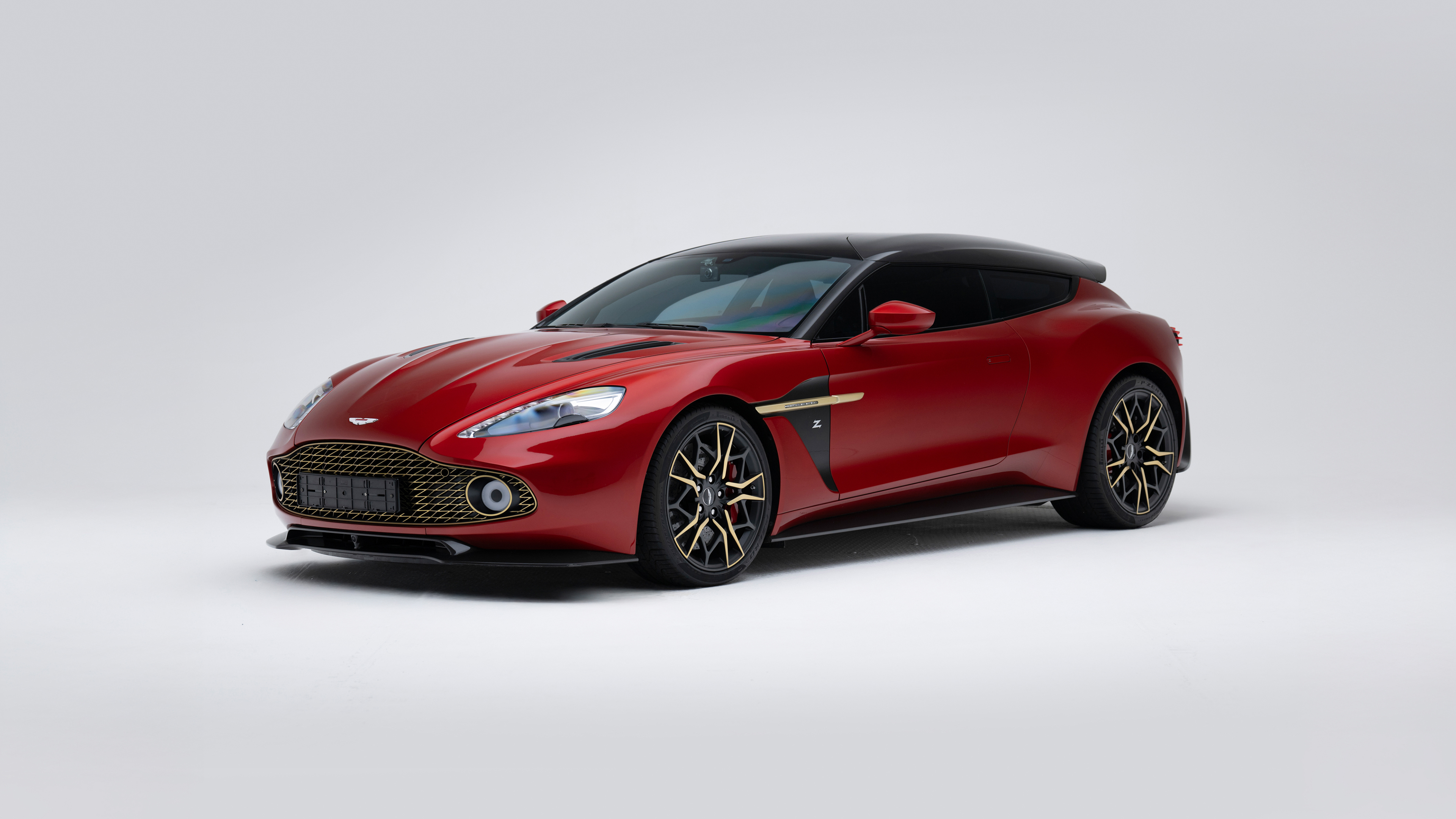A vibrant red Aston Martin Vanquish luxury sports car isolated on a solid white background.