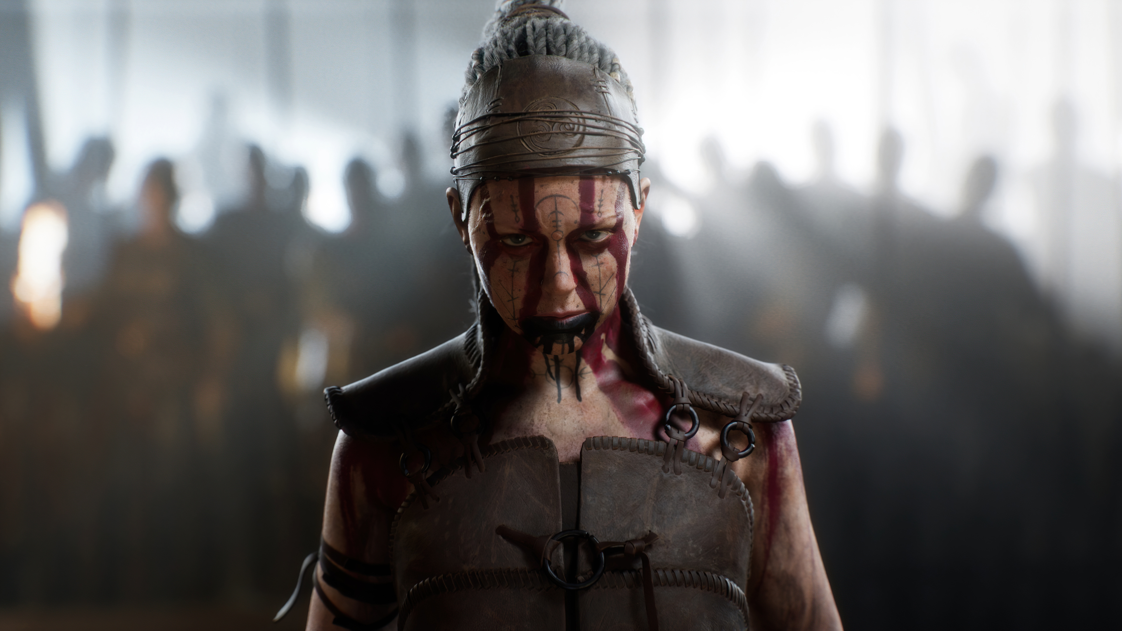 A cinematic close-up of the character Senua from Senua's Saga: Hellblade II, highlighting intense facial features and atmospheric lighting.