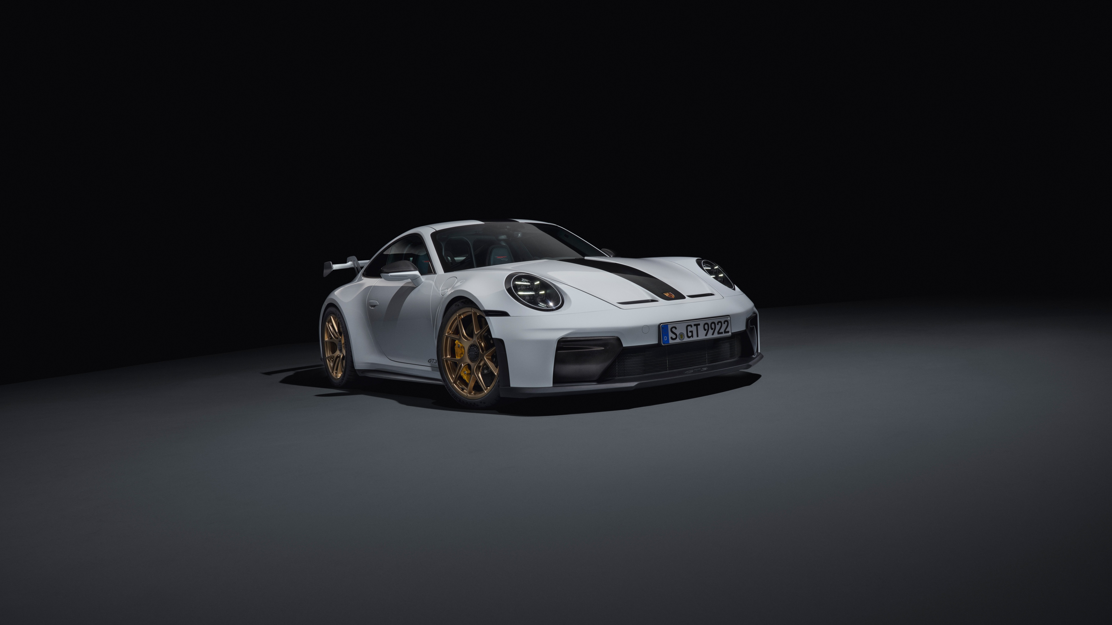 A high-detail, cinematic shot of a Porsche 911 GT3 positioned against a dark, moody background.
