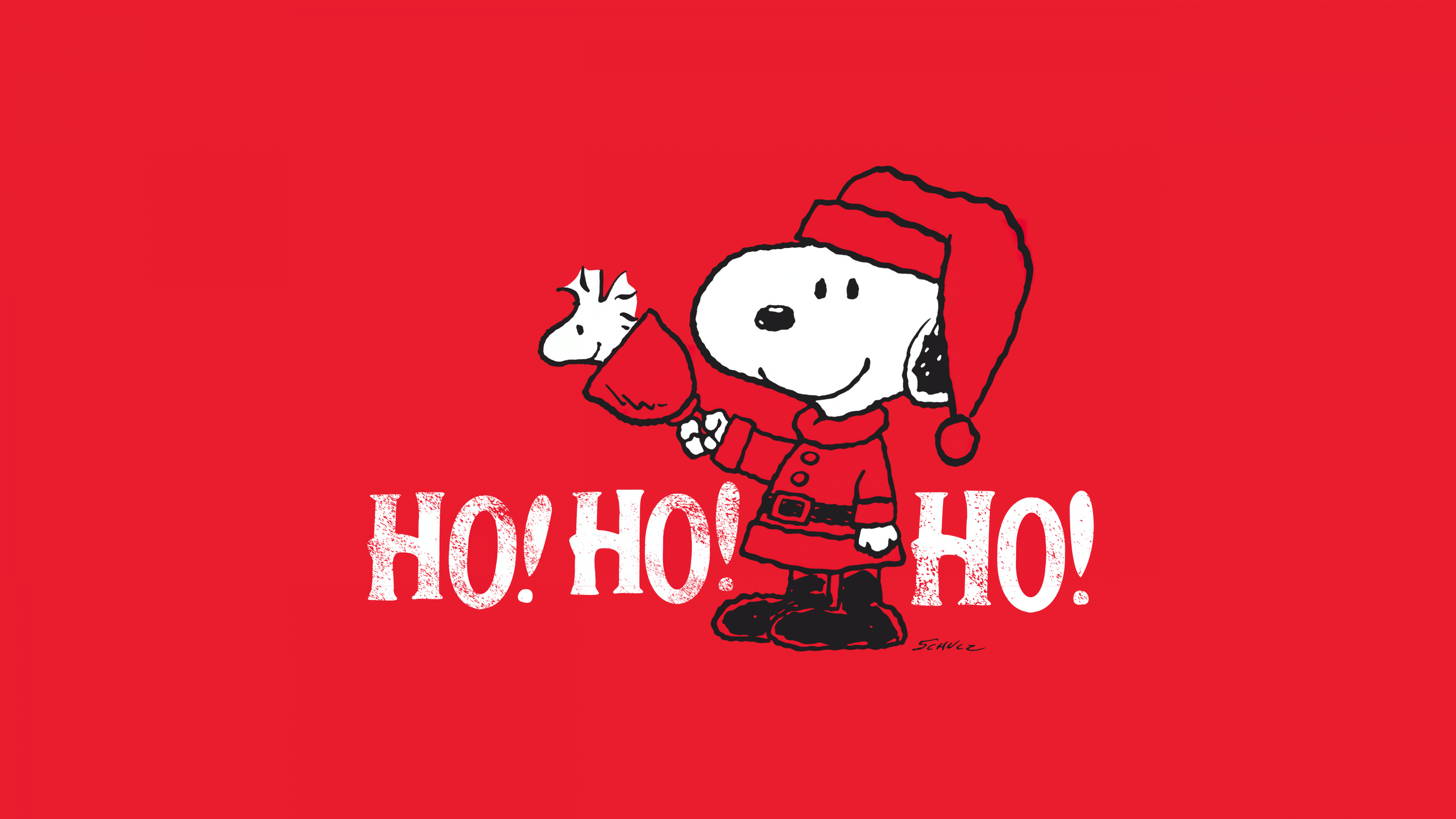 Snoopy from Peanuts wearing a Santa Claus hat in a red Christmas-themed setting.