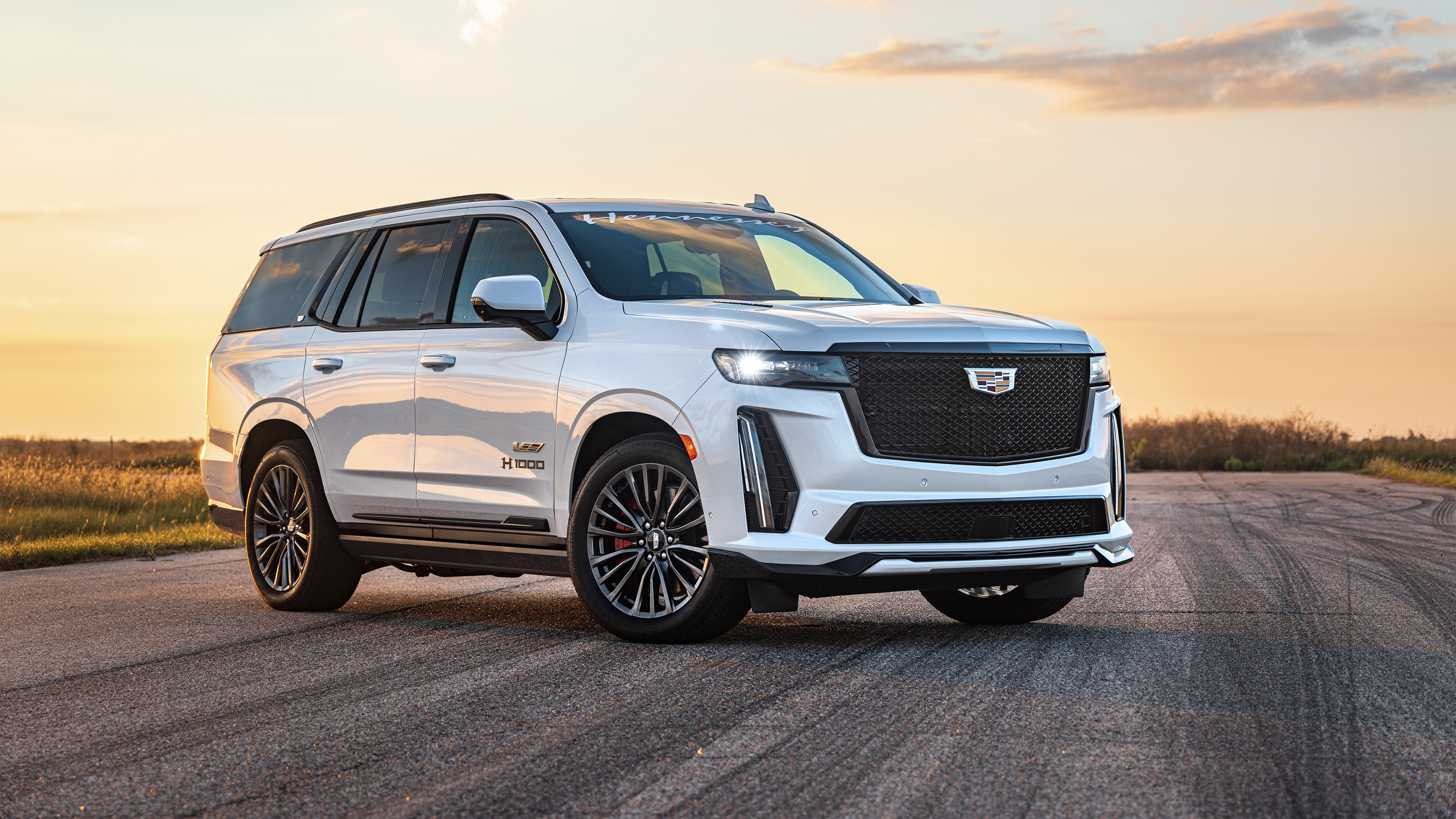 A high-end 2024 luxury SUV with a glossy finish parked in a modern metropolitan area.