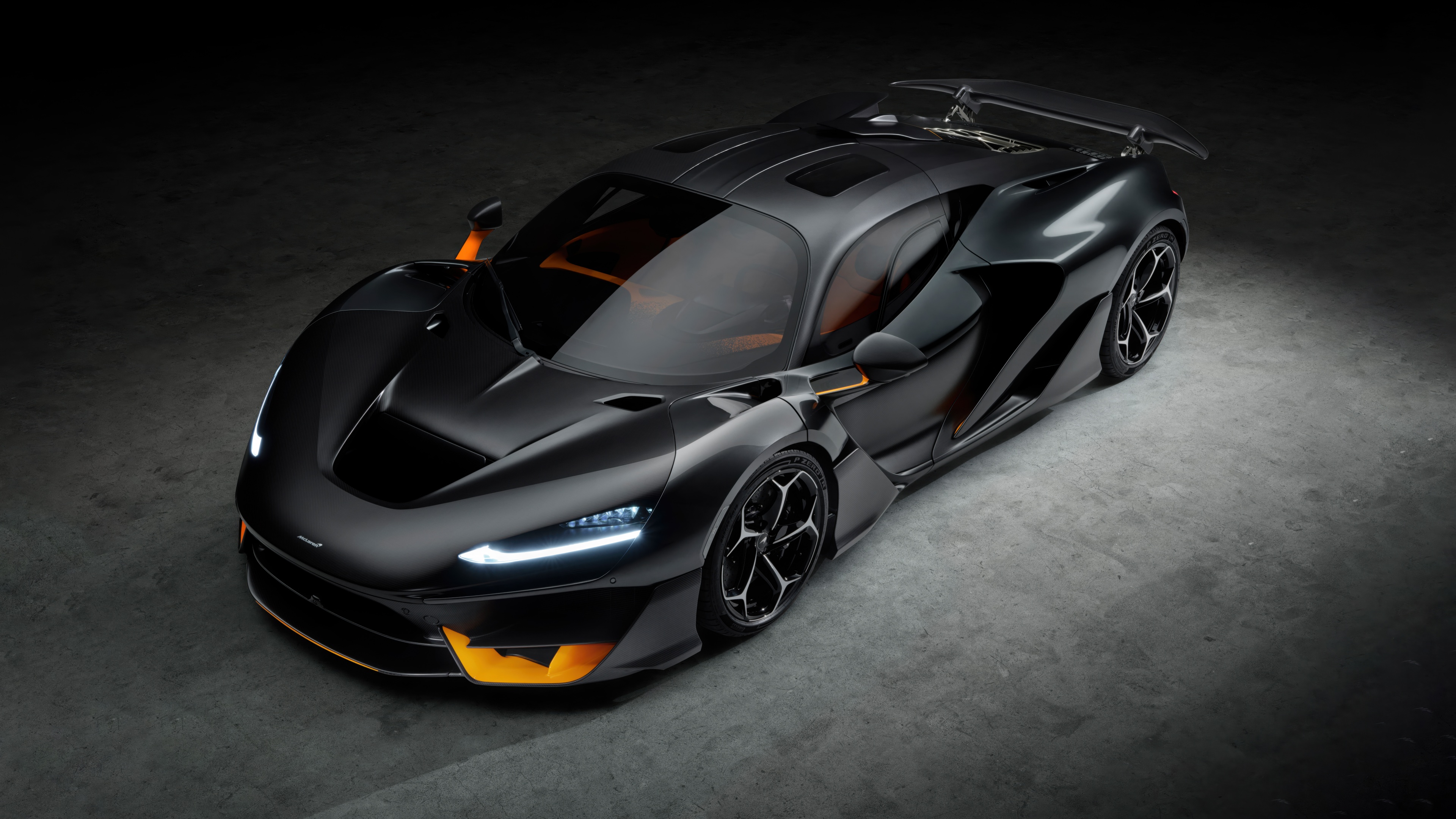 A cinematic, high-resolution close-up of a McLaren W1 supercar in a dark, moody setting, highlighting its sleek curves and carbon fiber details.