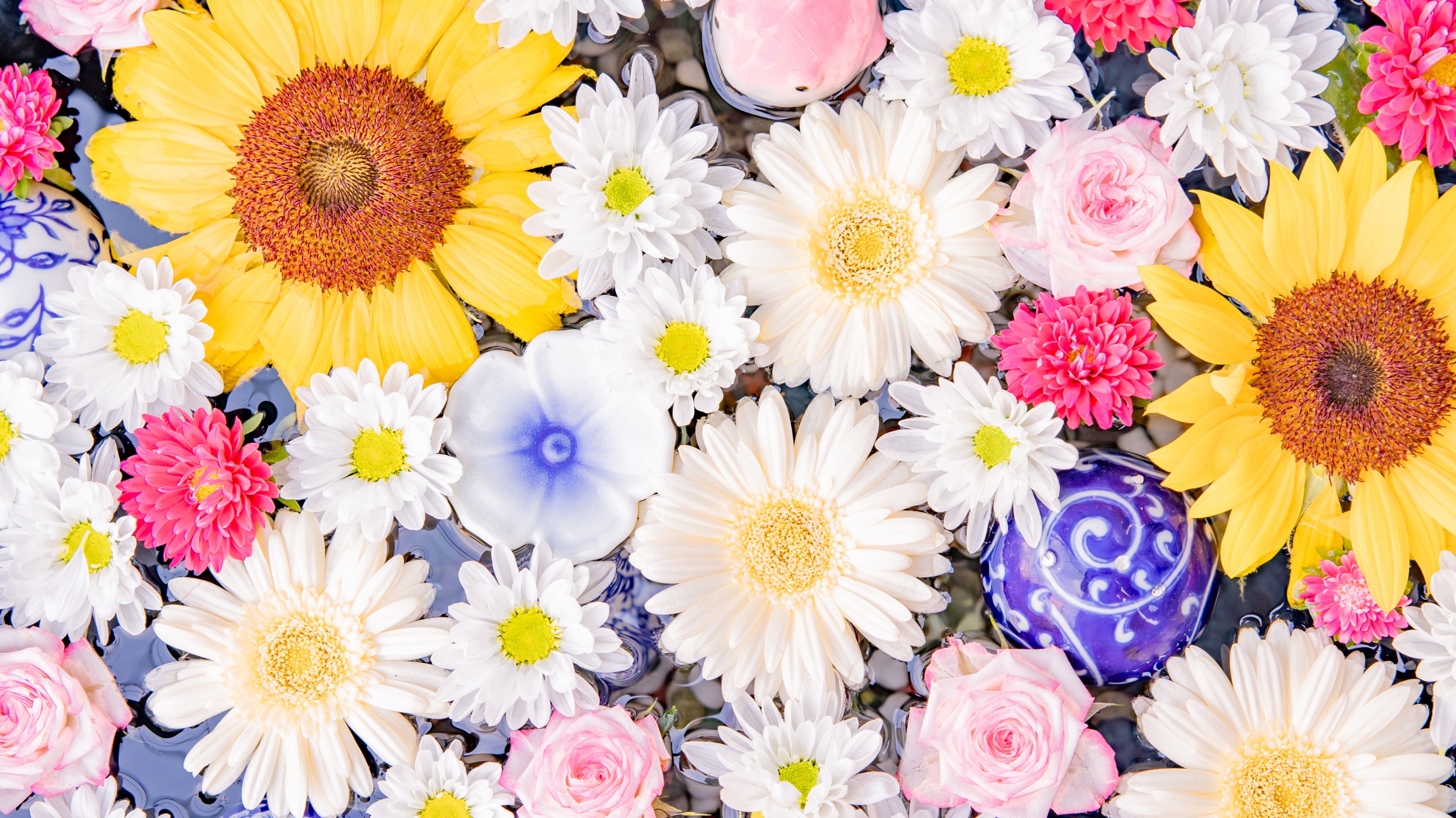 A colorful bouquet featuring bright yellow sunflowers and white daisy flowers.