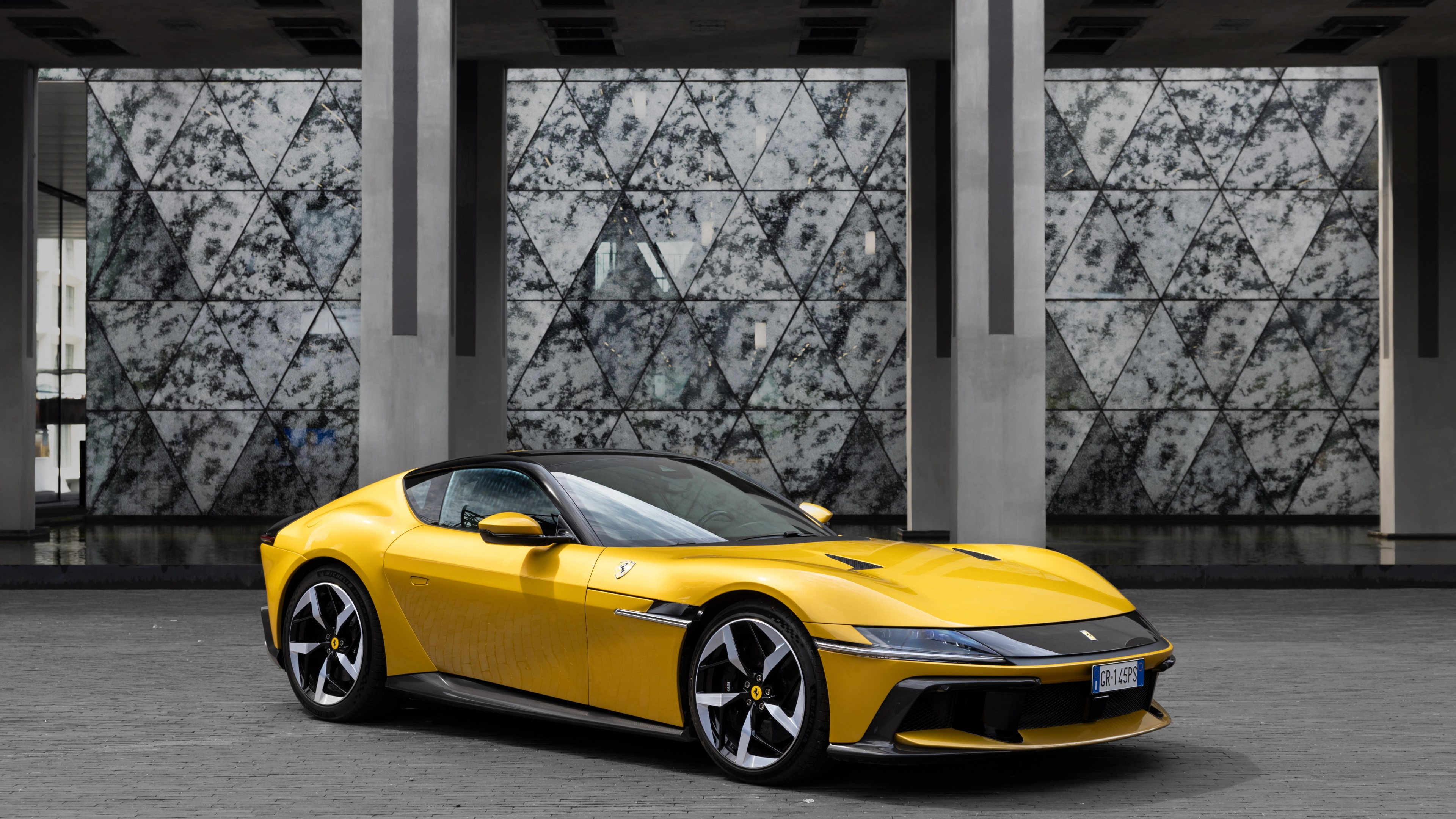 A high-resolution, detailed shot of a bright yellow Ferrari 12Cilindri luxury sports car.