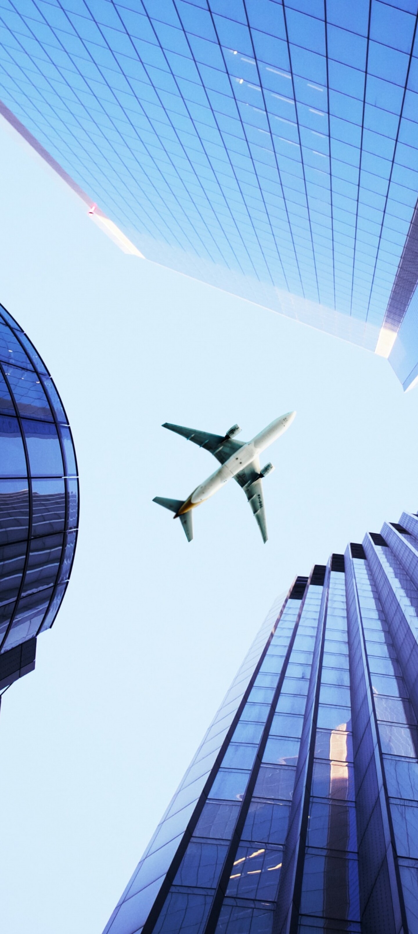 A wide-angle shot of a dense metropolis with massive skyscrapers and an airplane flying over the city skyline.
