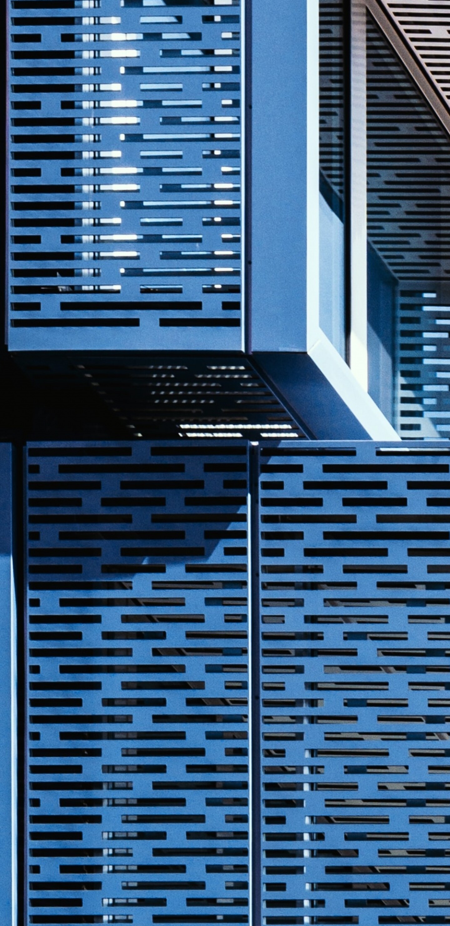 A symmetrical blue building featuring complex geometric patterns and modern architectural design.